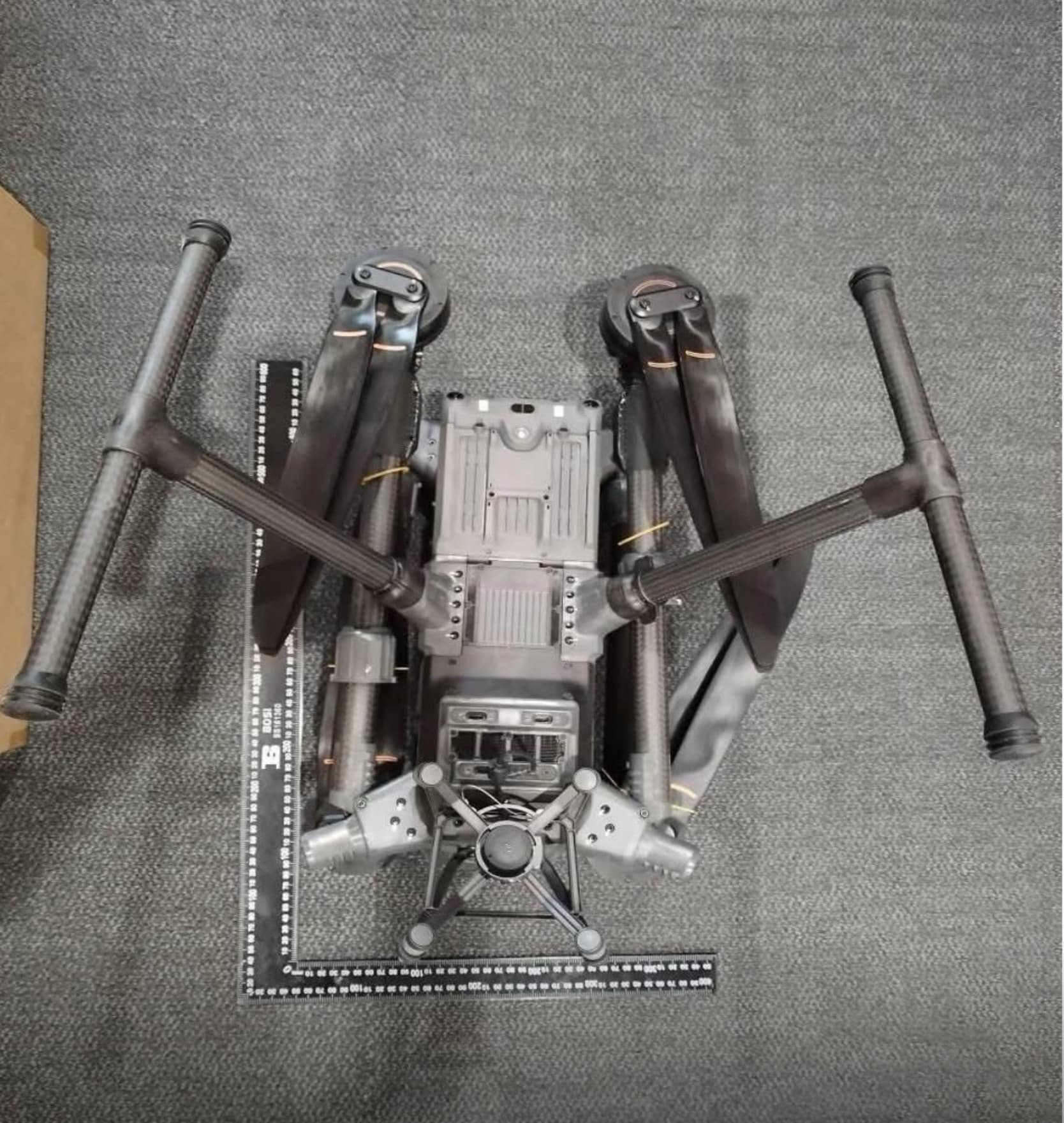Front view of the same drone with arms folded down and landing legs splayed.