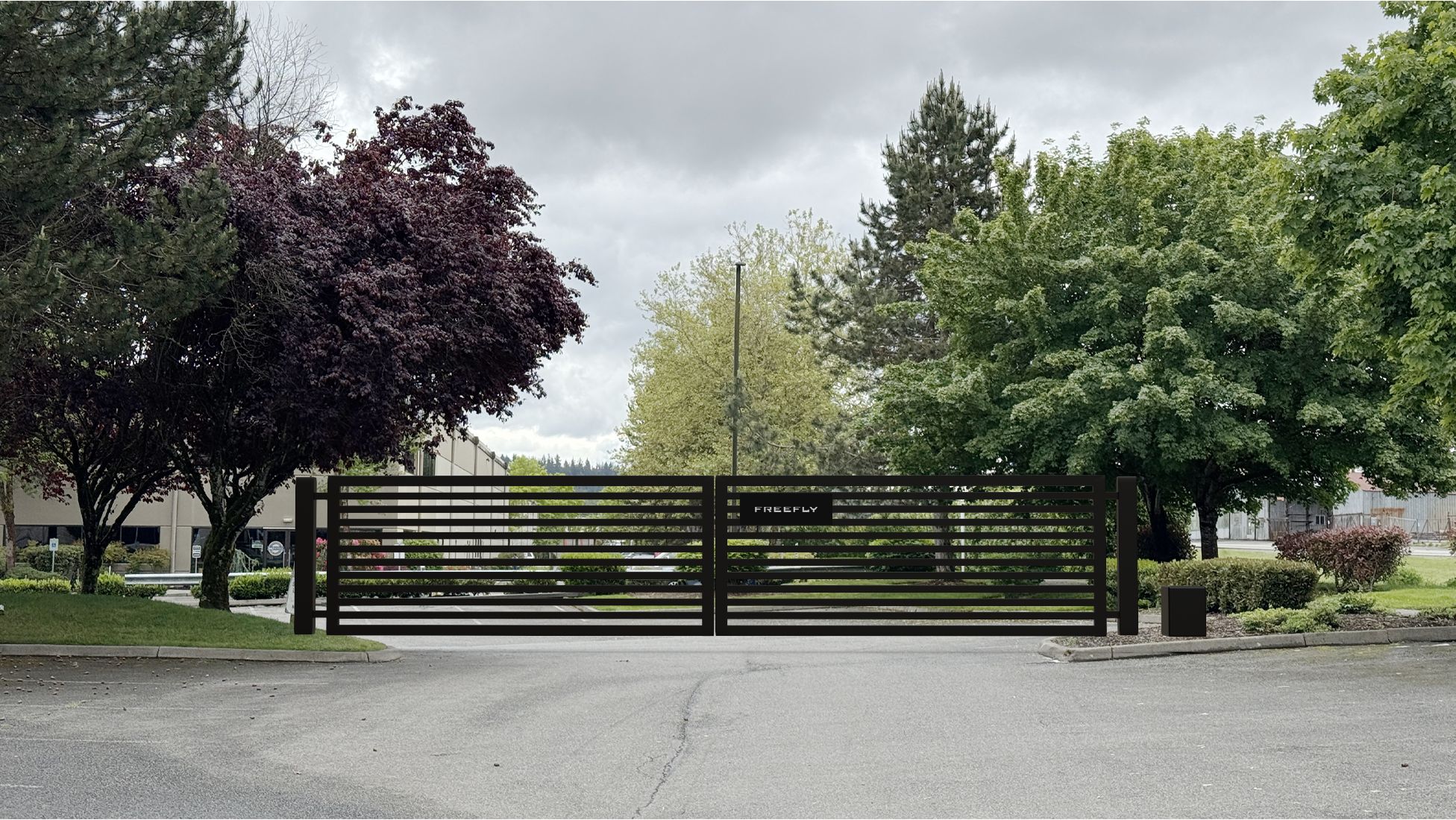 Dark metal gate across the driveway of the new headquarters on a grey day.