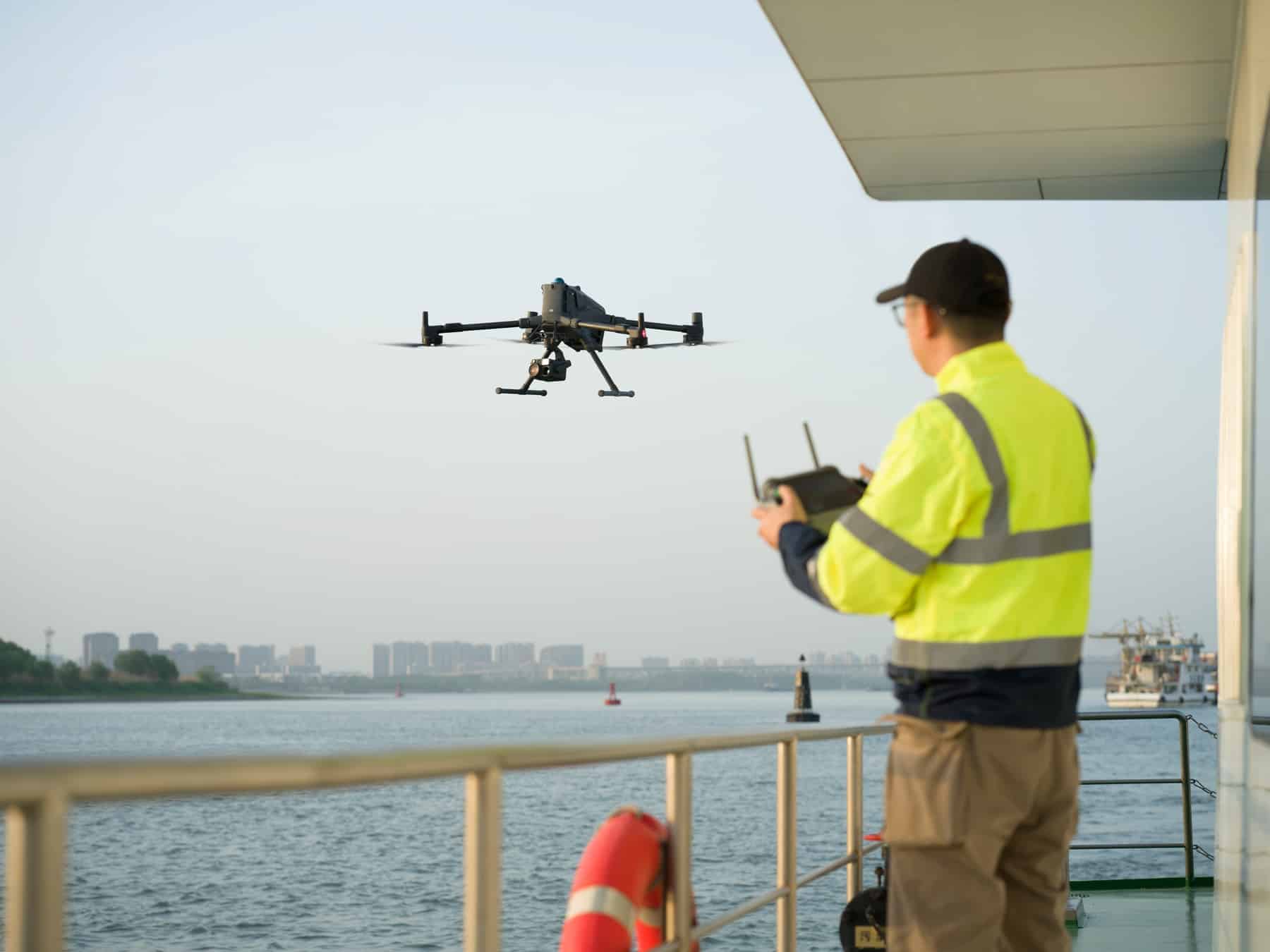 Operator on a vessel deck flies the Matrice 400 with a handheld controller.