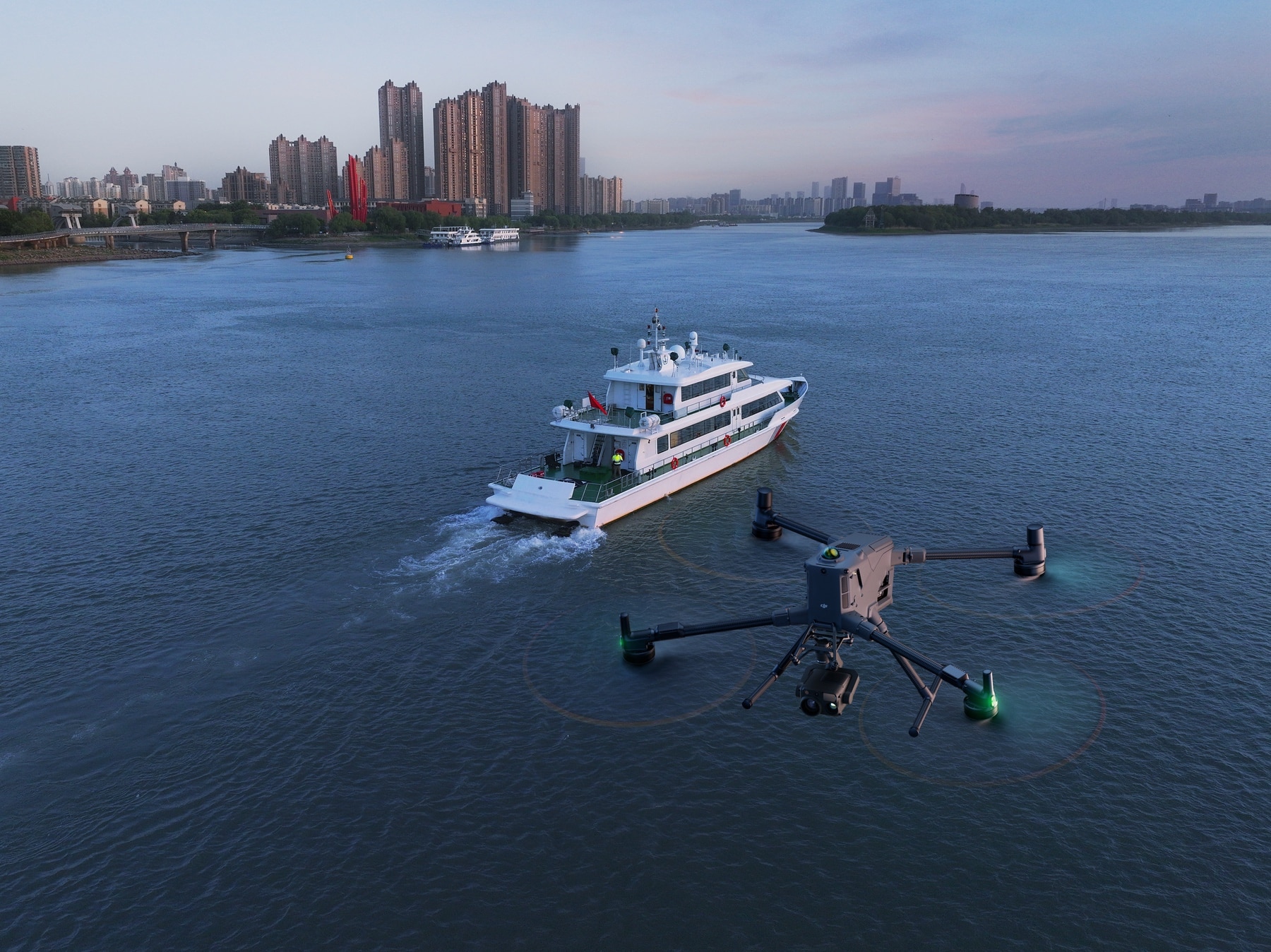 Aerial view of the drone trailing a white passenger ferry across open water.
