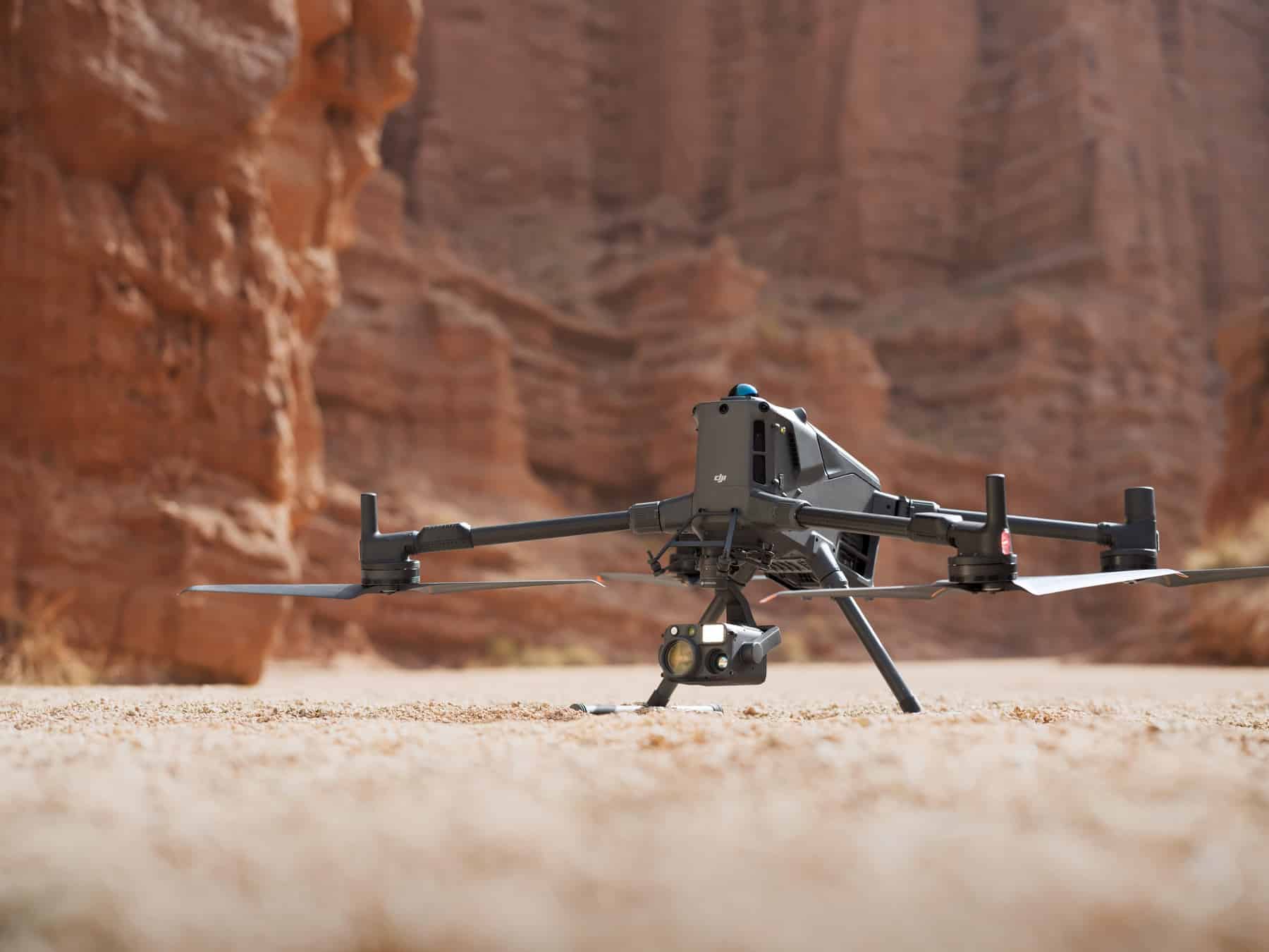 Landing gear almost touching, the drone settles onto the desert canyon floor.