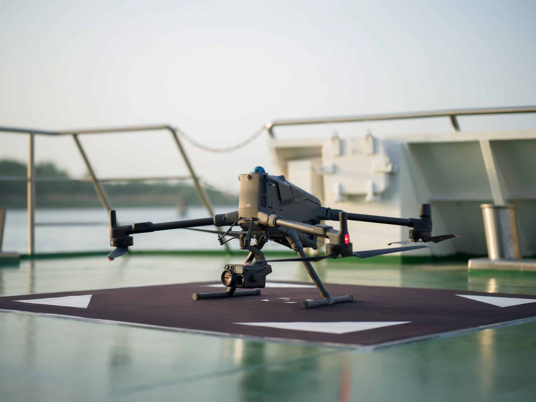 Enterprise drone parked on a dark landing pad aboard a ship deck.