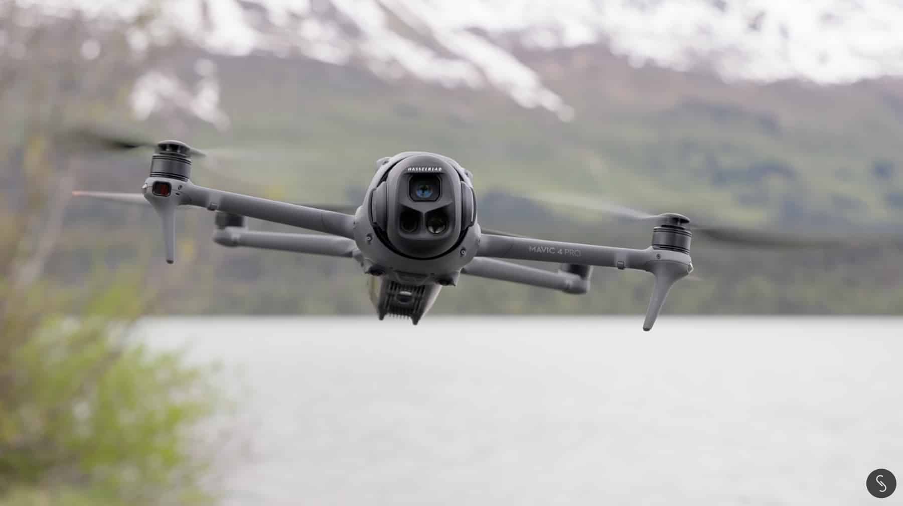 The Air 3S hovers above a pale grey lake with a snowy shoreline behind.