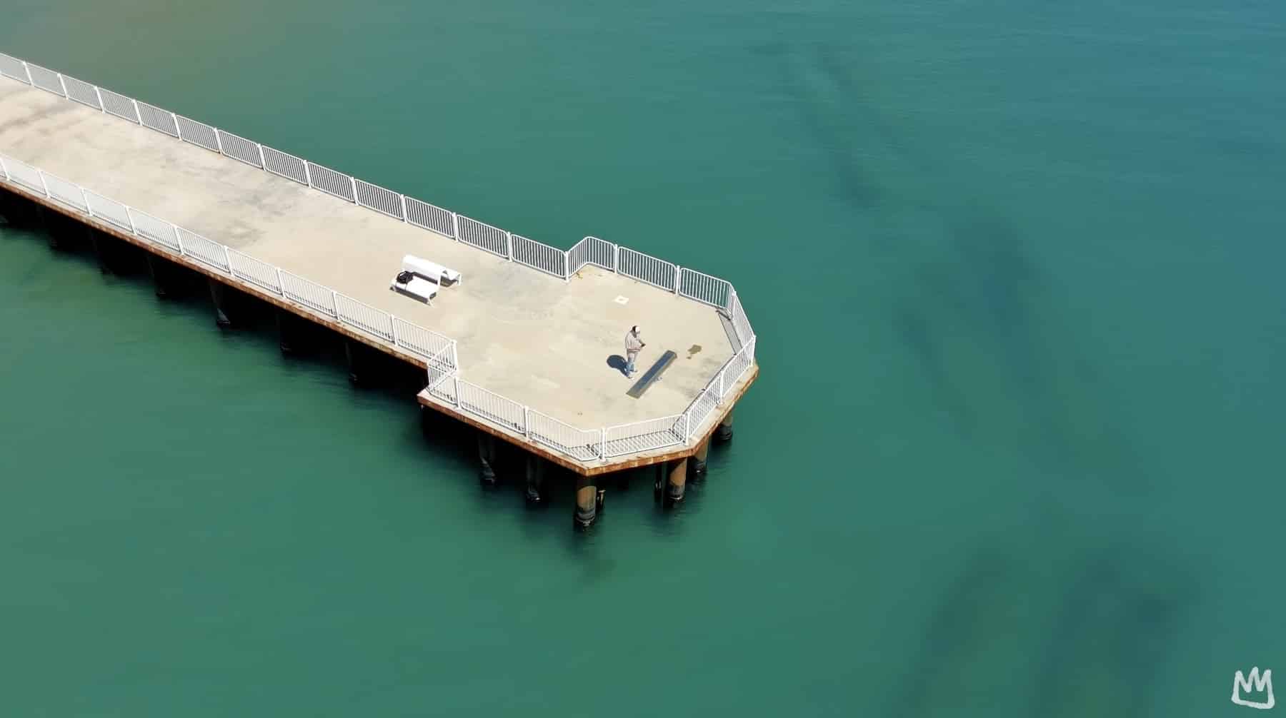 Aerial sample frame from the Atom 2 showing a pier over turquoise water.