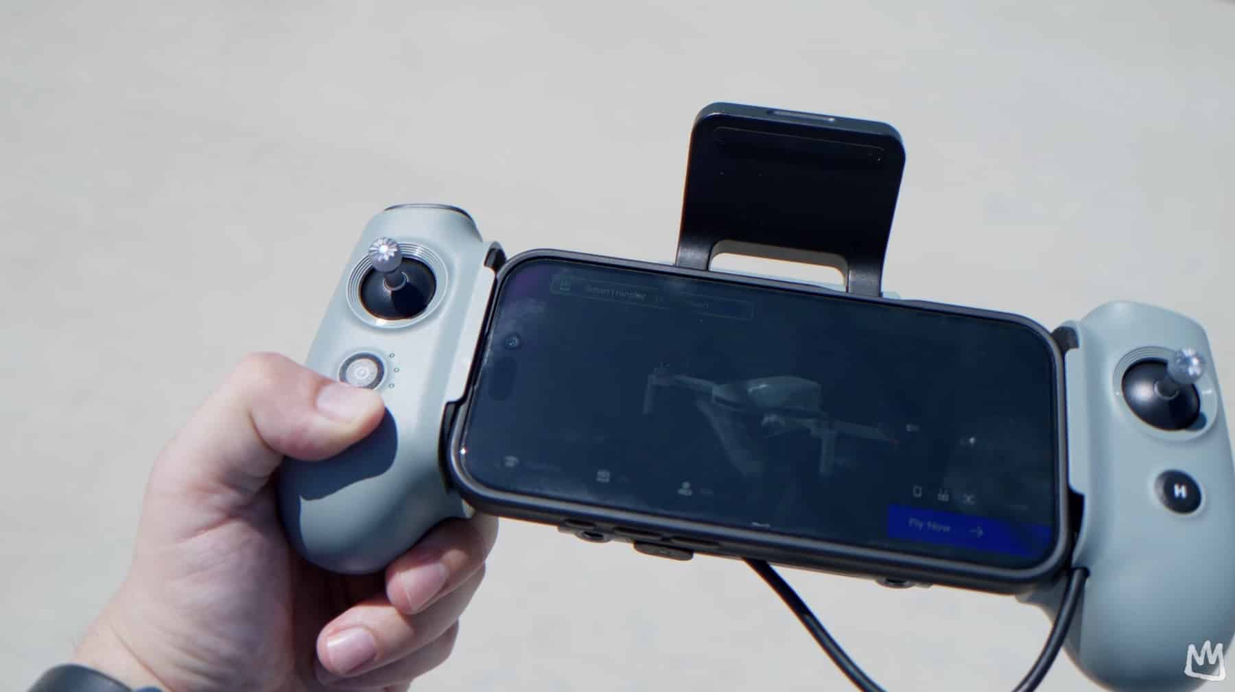 The Atom 2 remote controller held with a phone clamped in its holder.