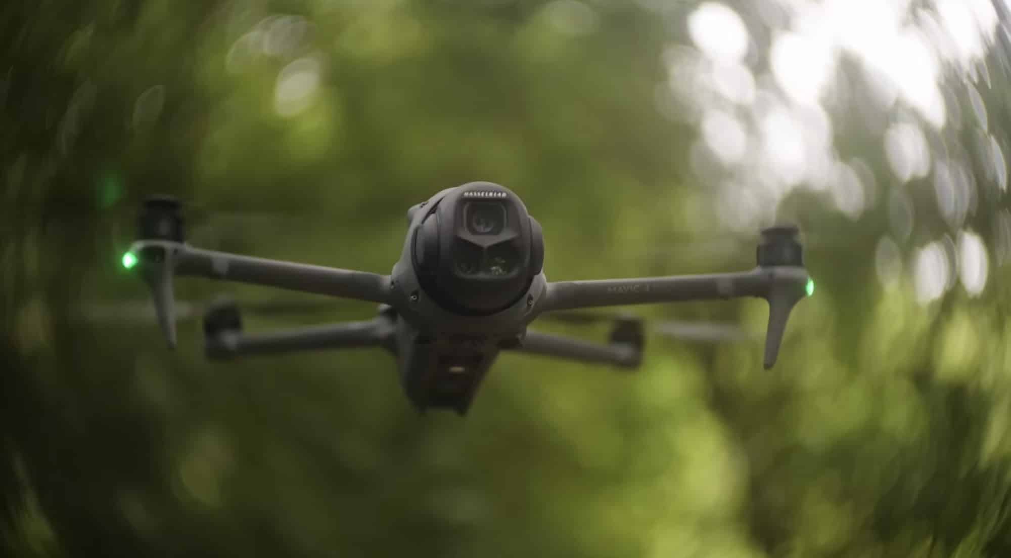 Front view of the drone in flight with its green navigation light lit.
