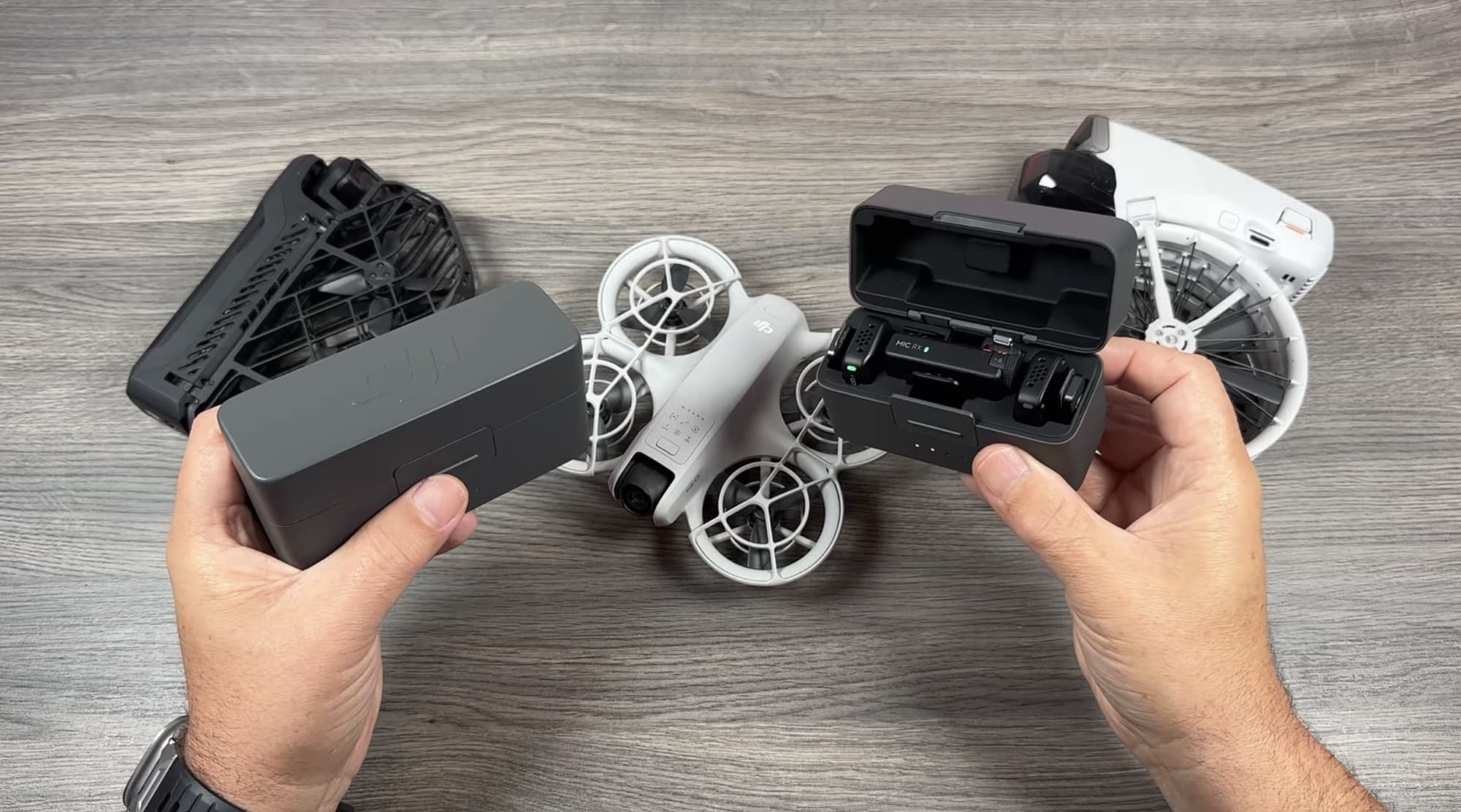 Hands hold a DJI Mic charging case and the open Mic Mini case.