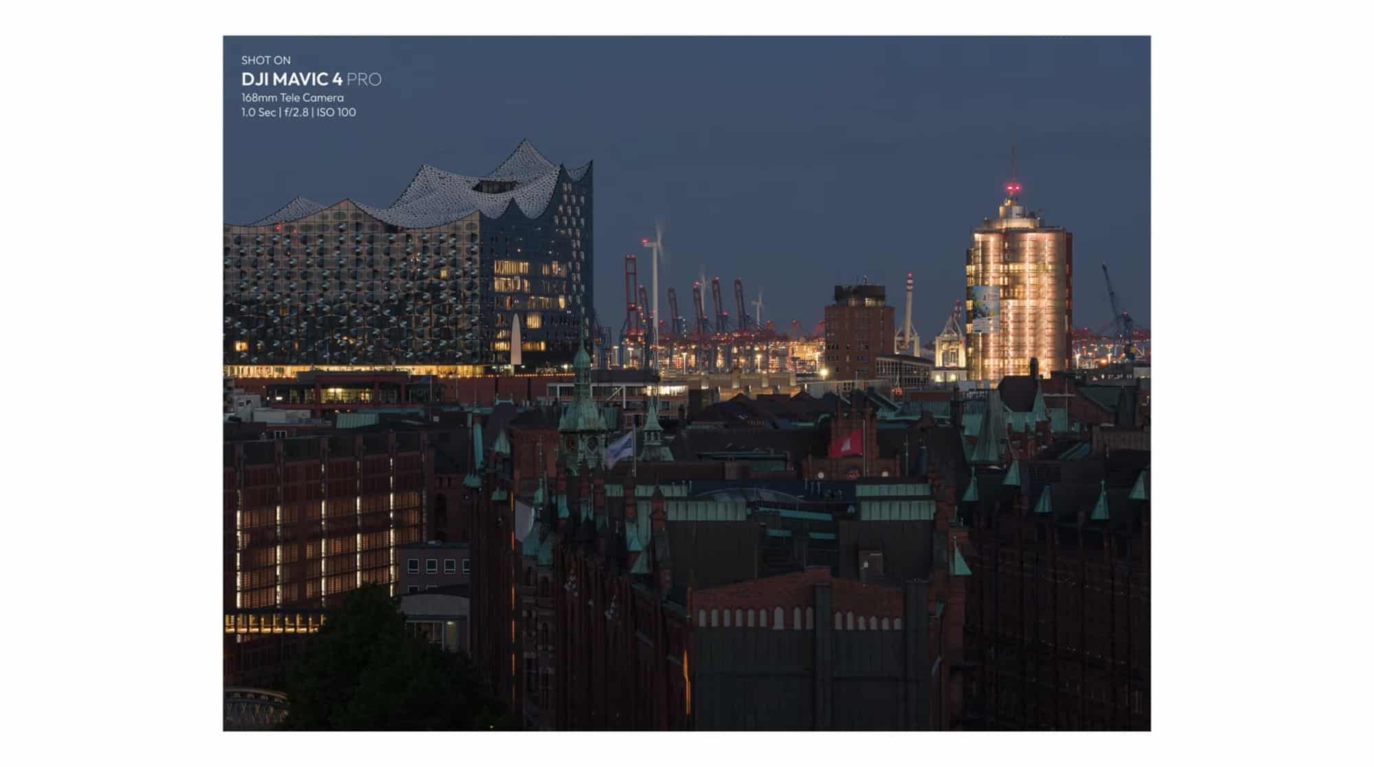 Compressed 168mm telephoto view of the Elbphilharmonie and harbor towers after sunset.