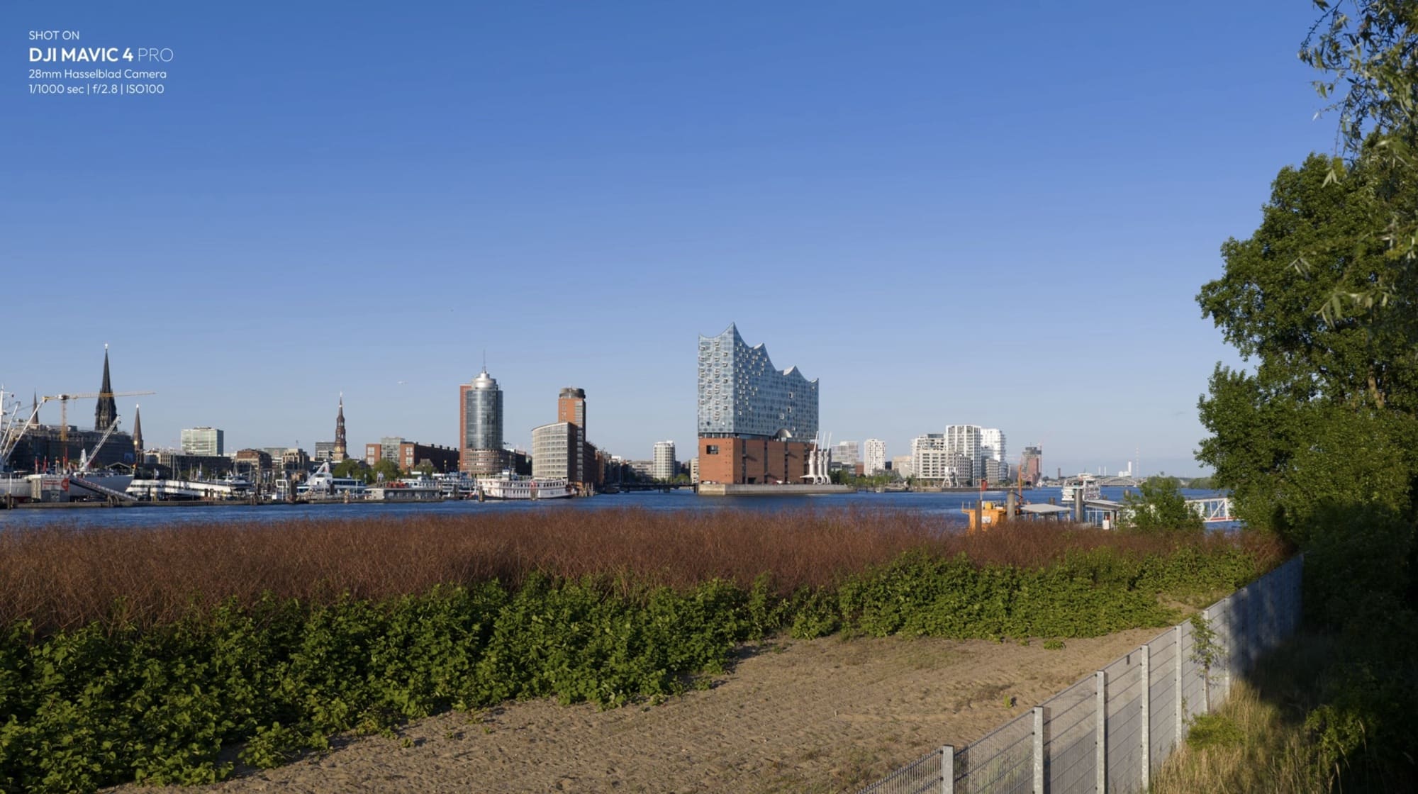Hamburg skyline beyond a grassy embankment, shot at 1/1000 second and ISO 100.