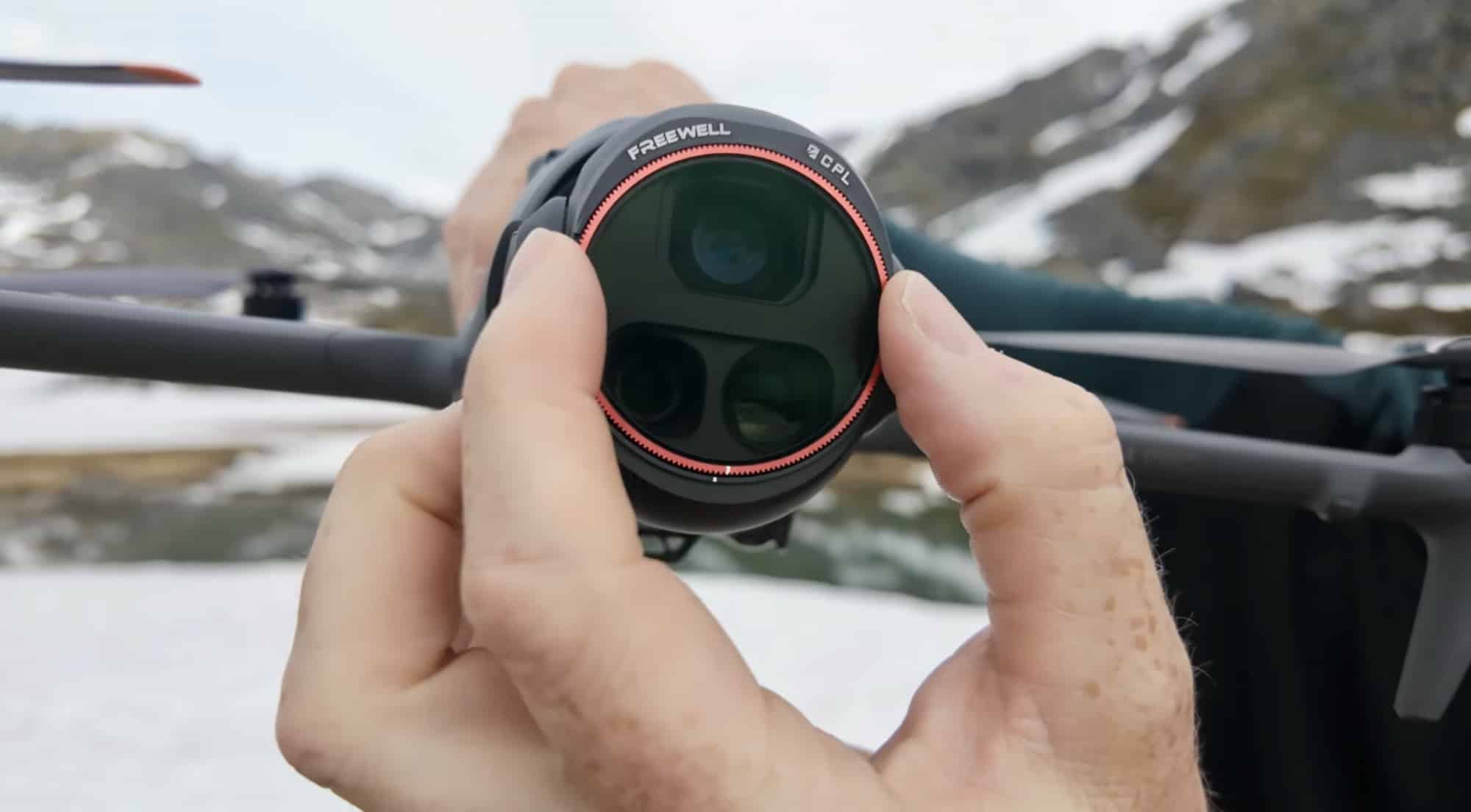 Hands twist a polarizing filter onto the drone camera cluster.