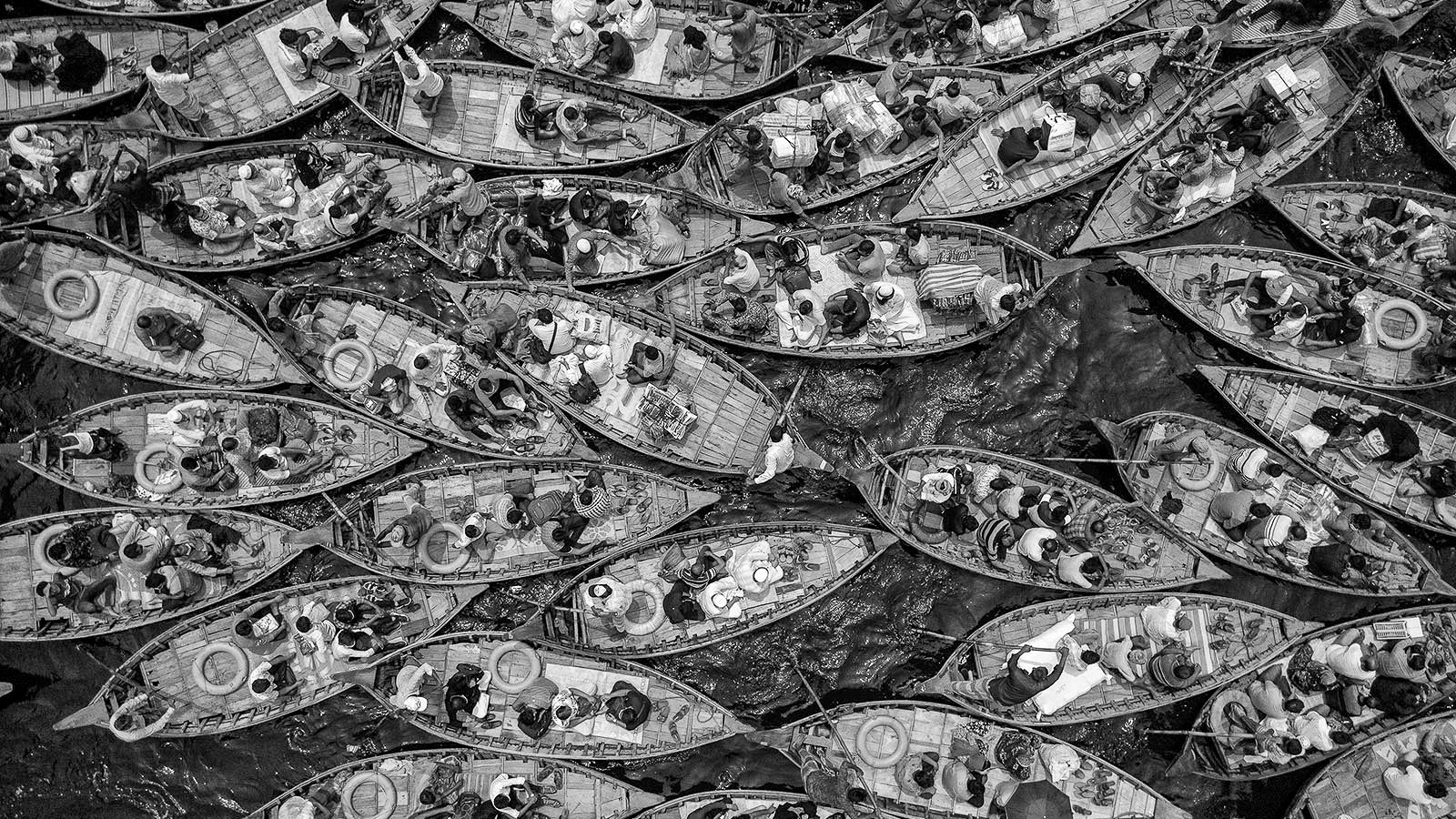 Black and white overhead of boats packed tightly against each other.