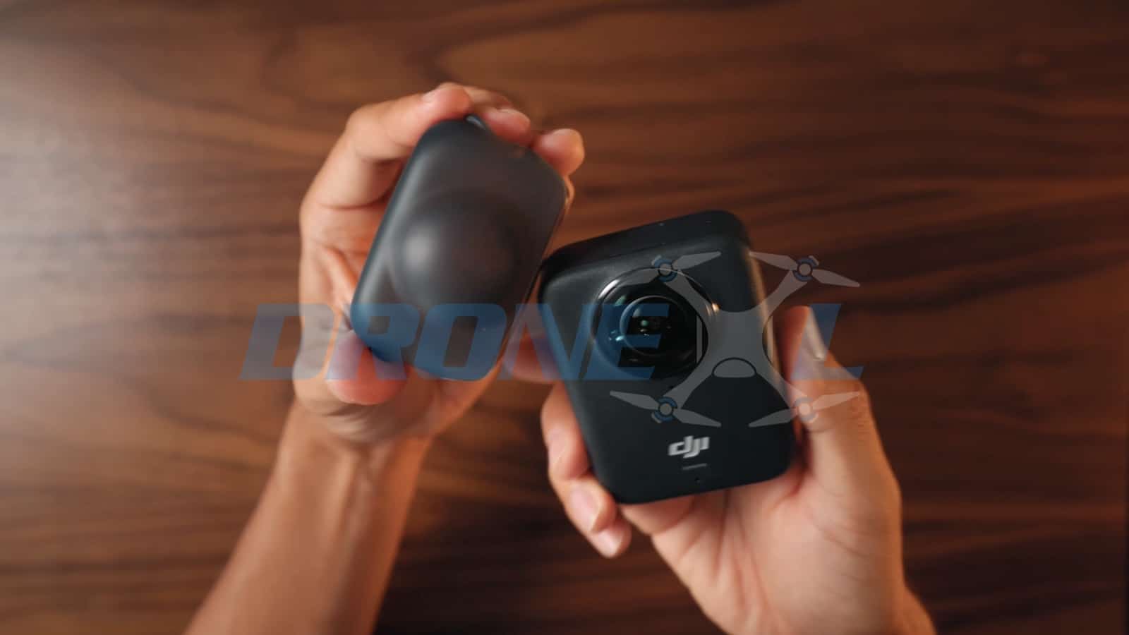 One hand offering the rubber lens protector while the other holds the camera body.