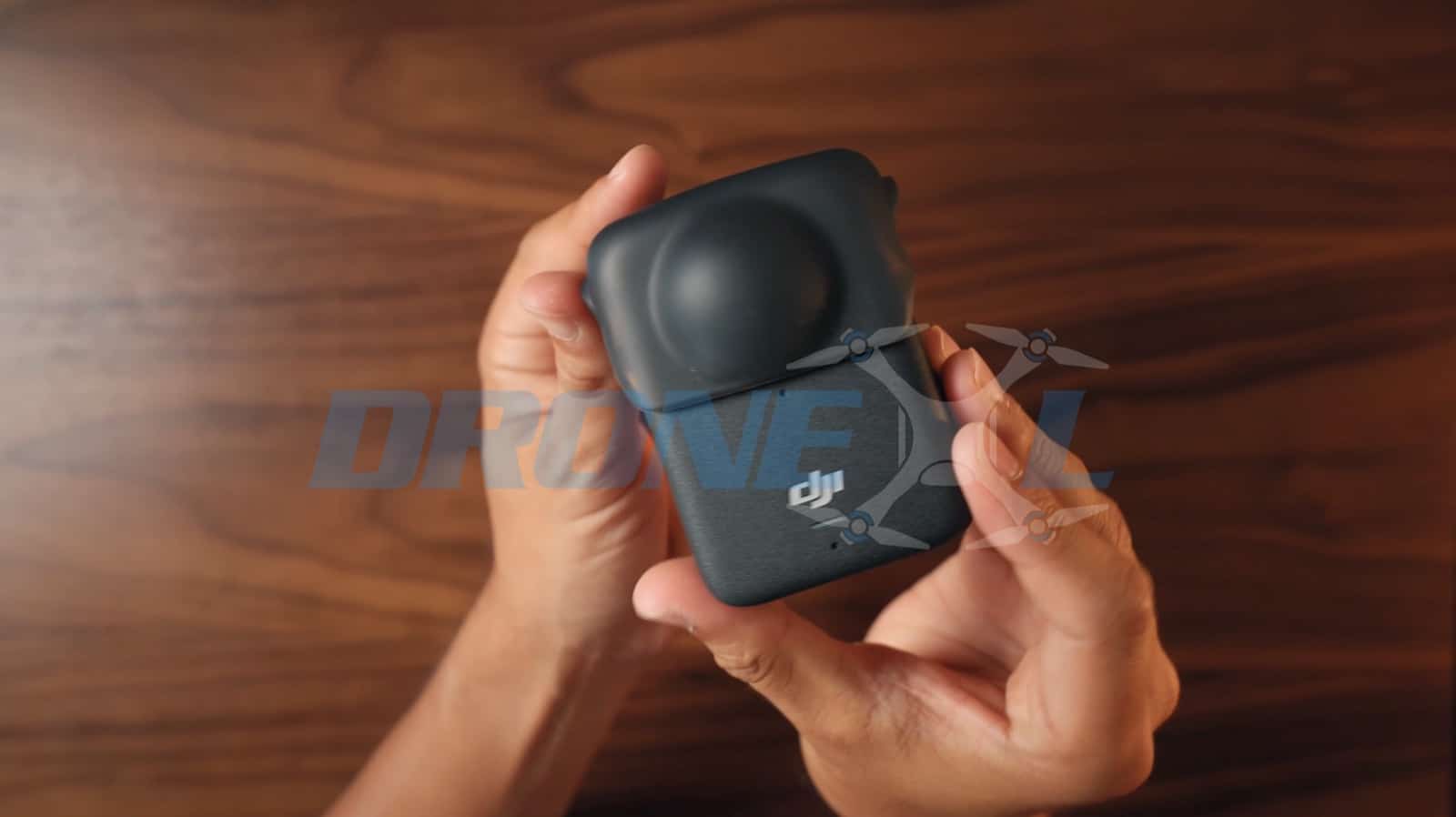 Fingers pressing the rubber lens protector onto the front fisheye lens.
