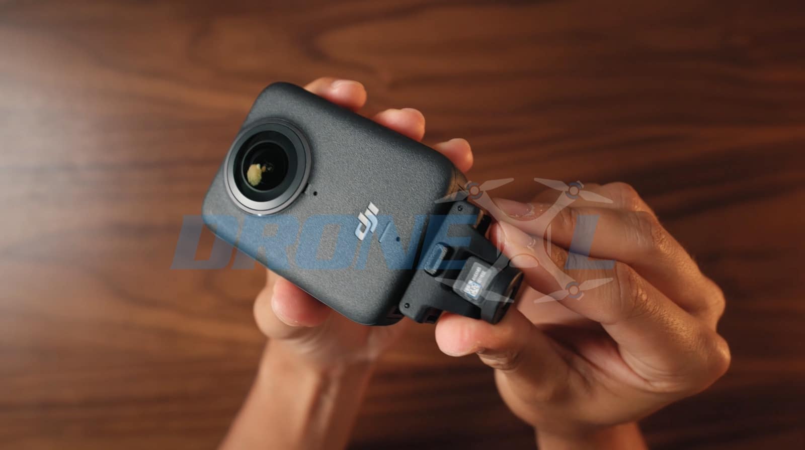 Hands clipping the quick-release adapter onto the base of the camera.