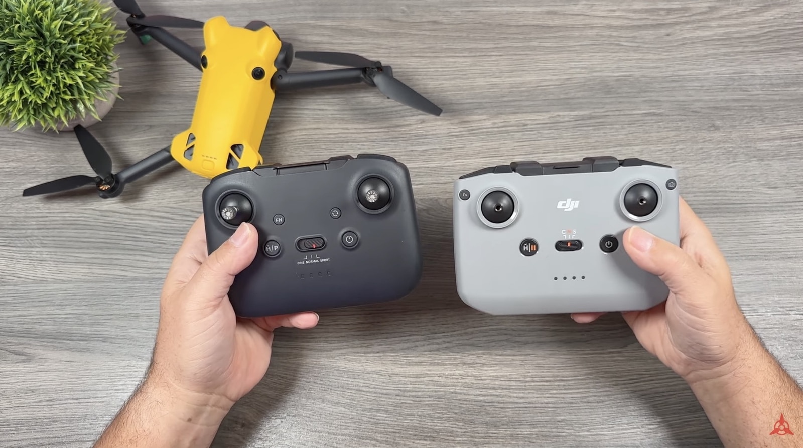 Two remote controllers held side by side, one black and one white.