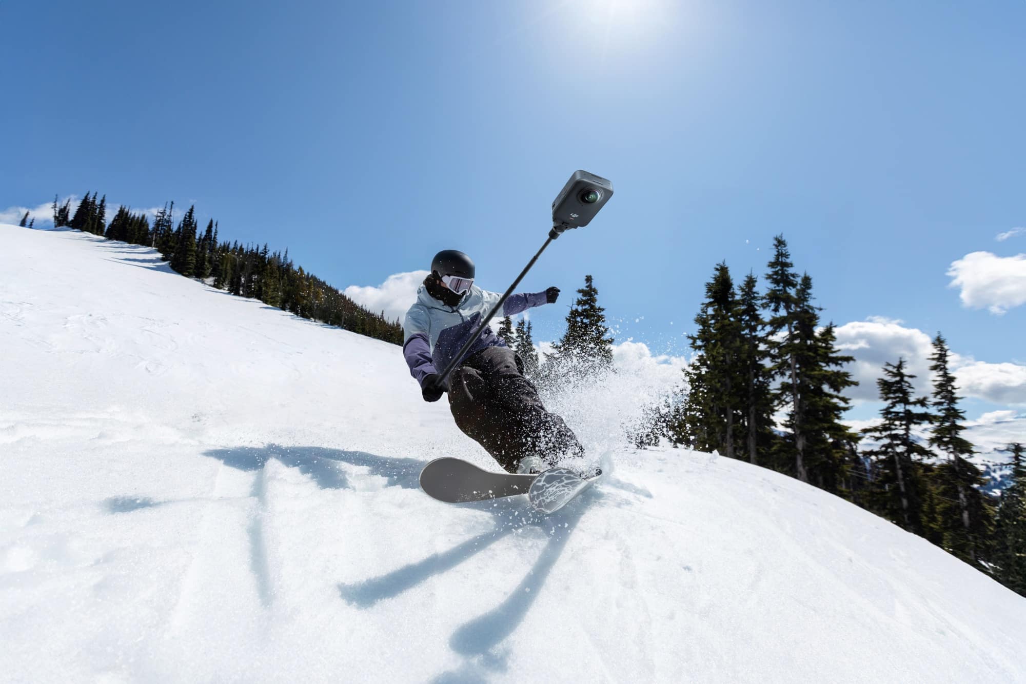 A skier carves through fresh powder with the camera on a helmet arm.