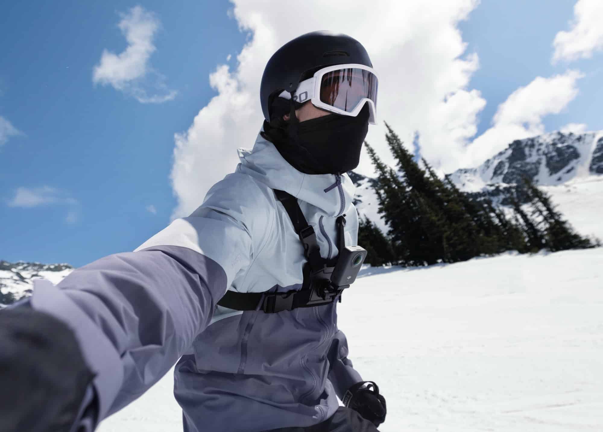 Selfie angle of a skier in helmet and face mask filmed from a chest-strap mount.