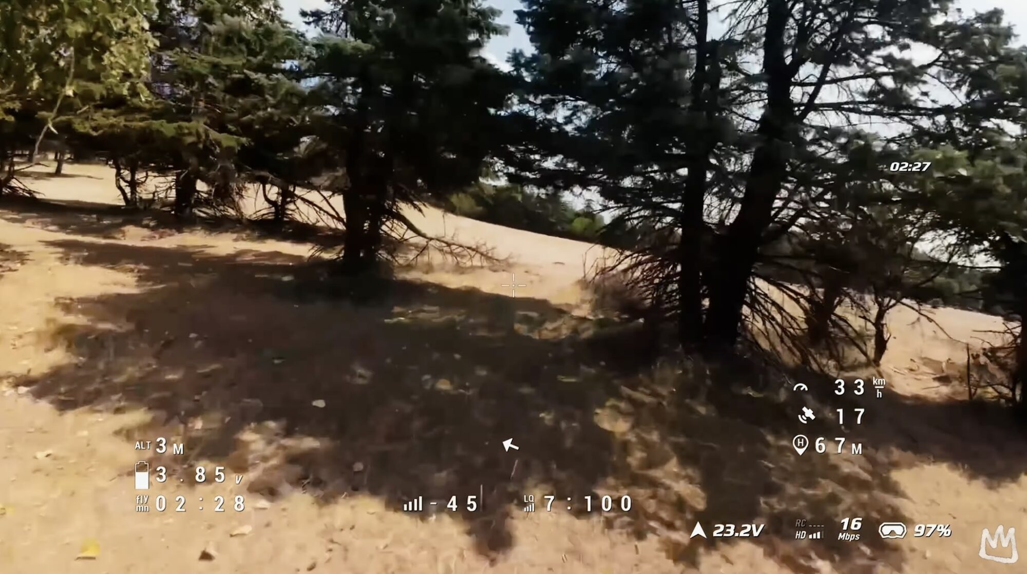 Analog goggle feed of pine trees above sand dunes with telemetry overlaid.