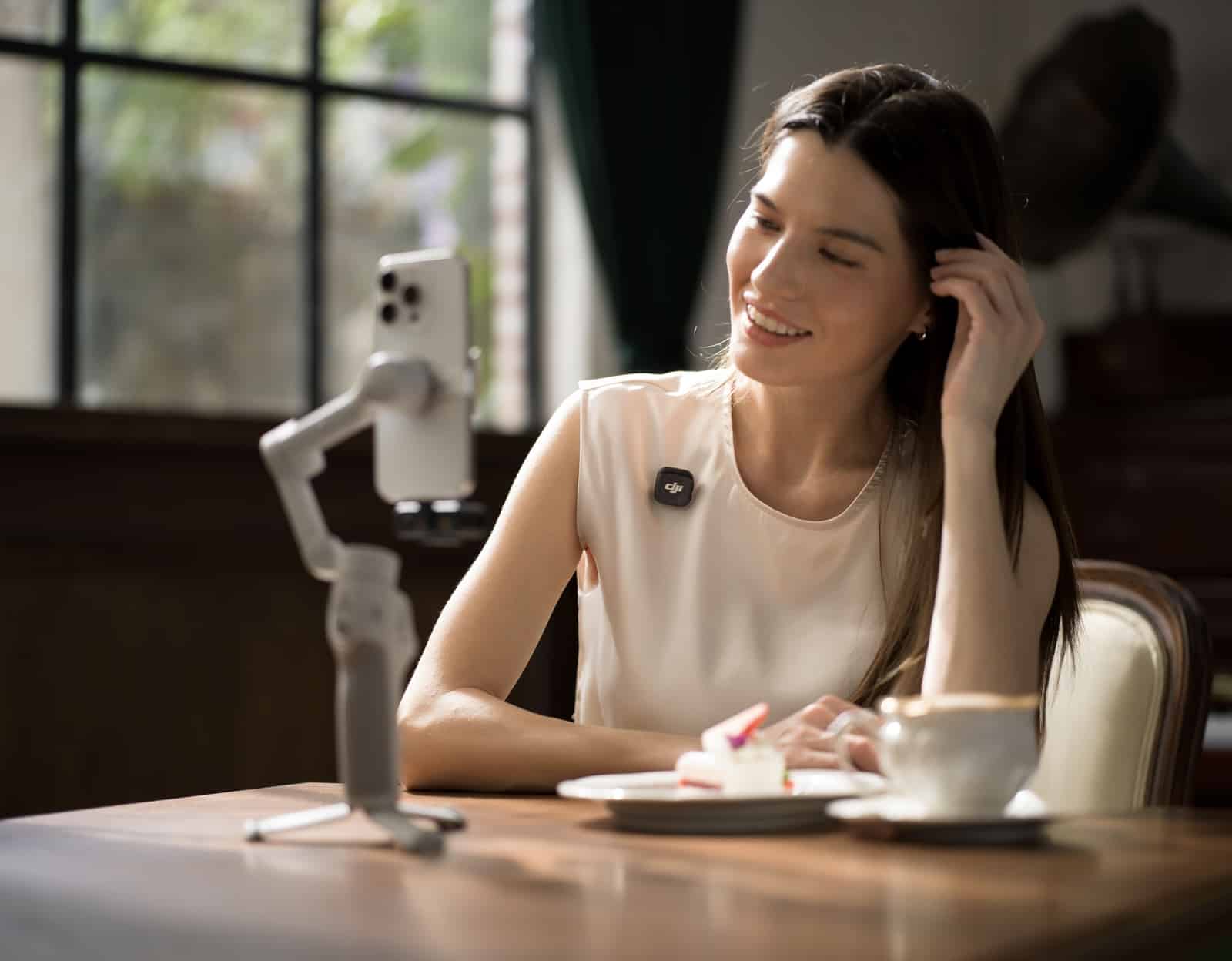 A DJI Mic 3 transmitter paired with the Osmo Mobile 7 smartphone gimbal.