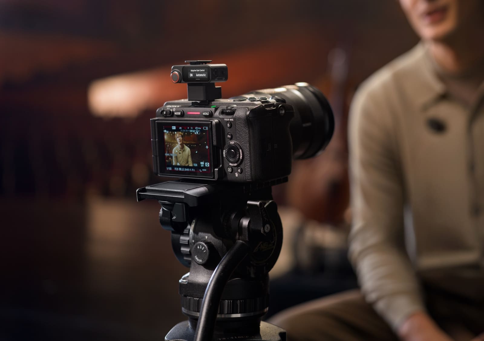 Cinema camera on a tripod with the receiver seated in its hot shoe.