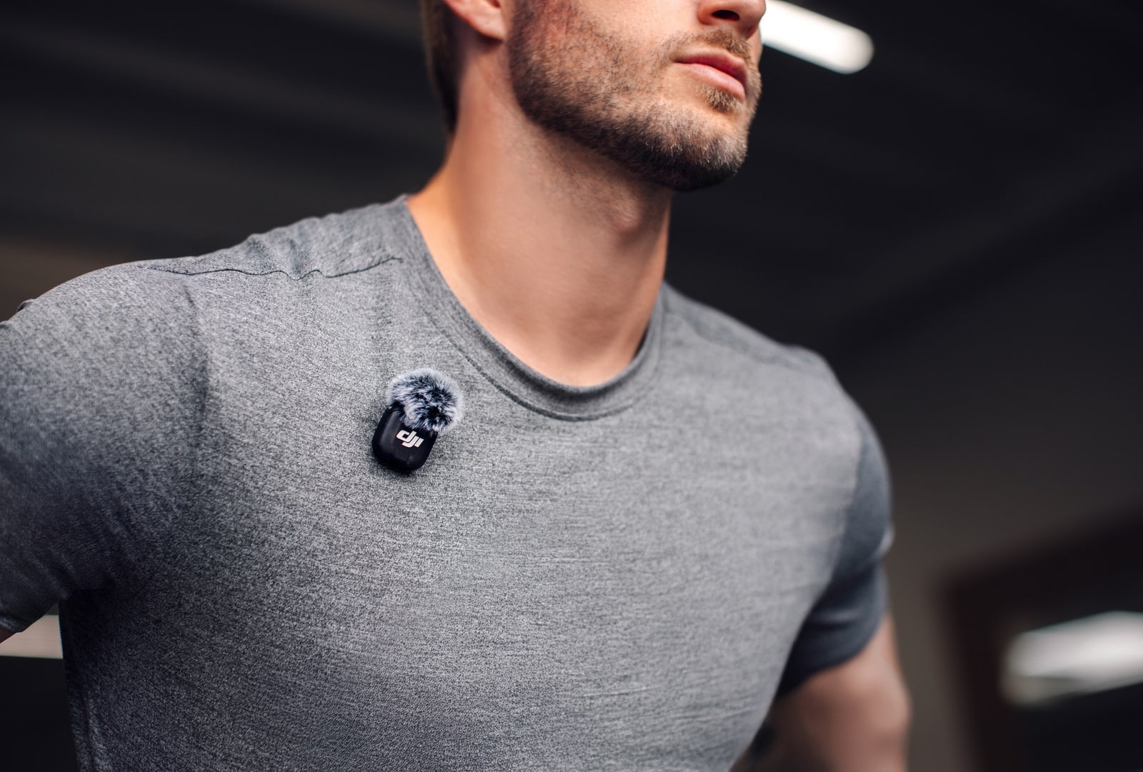 Close-up of a transmitter clipped to a gray T-shirt at the shoulder.