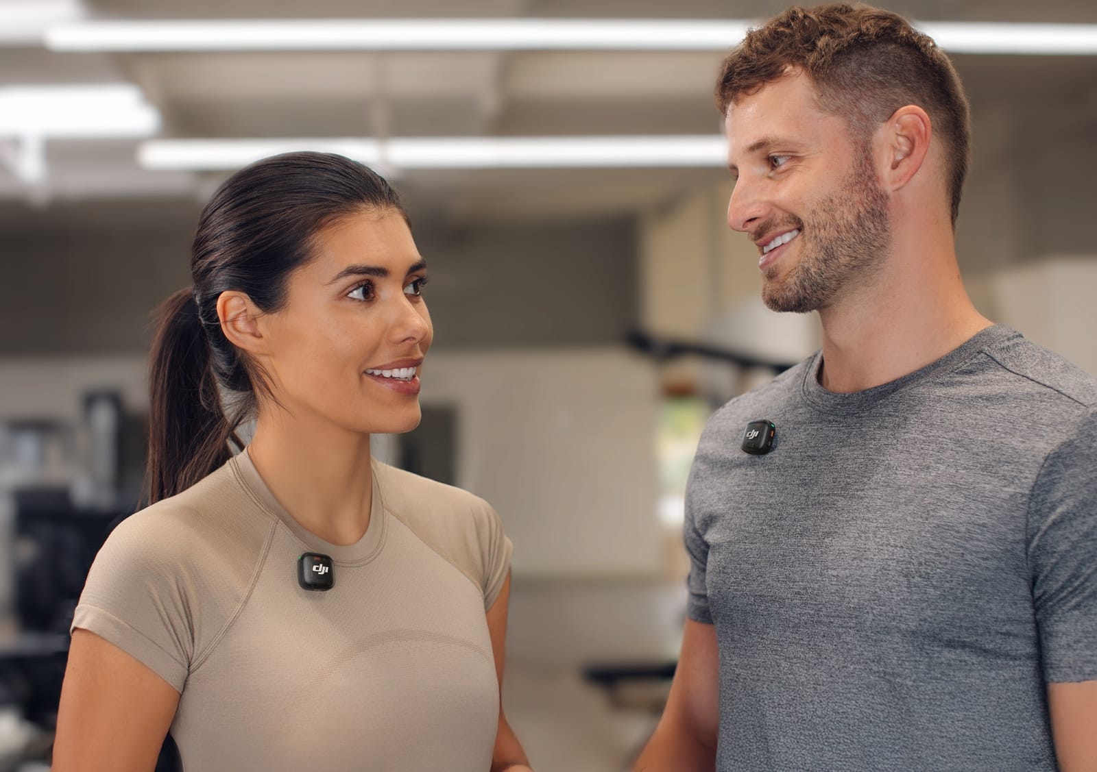 Woman and man in a gym face each other, each wearing a transmitter.