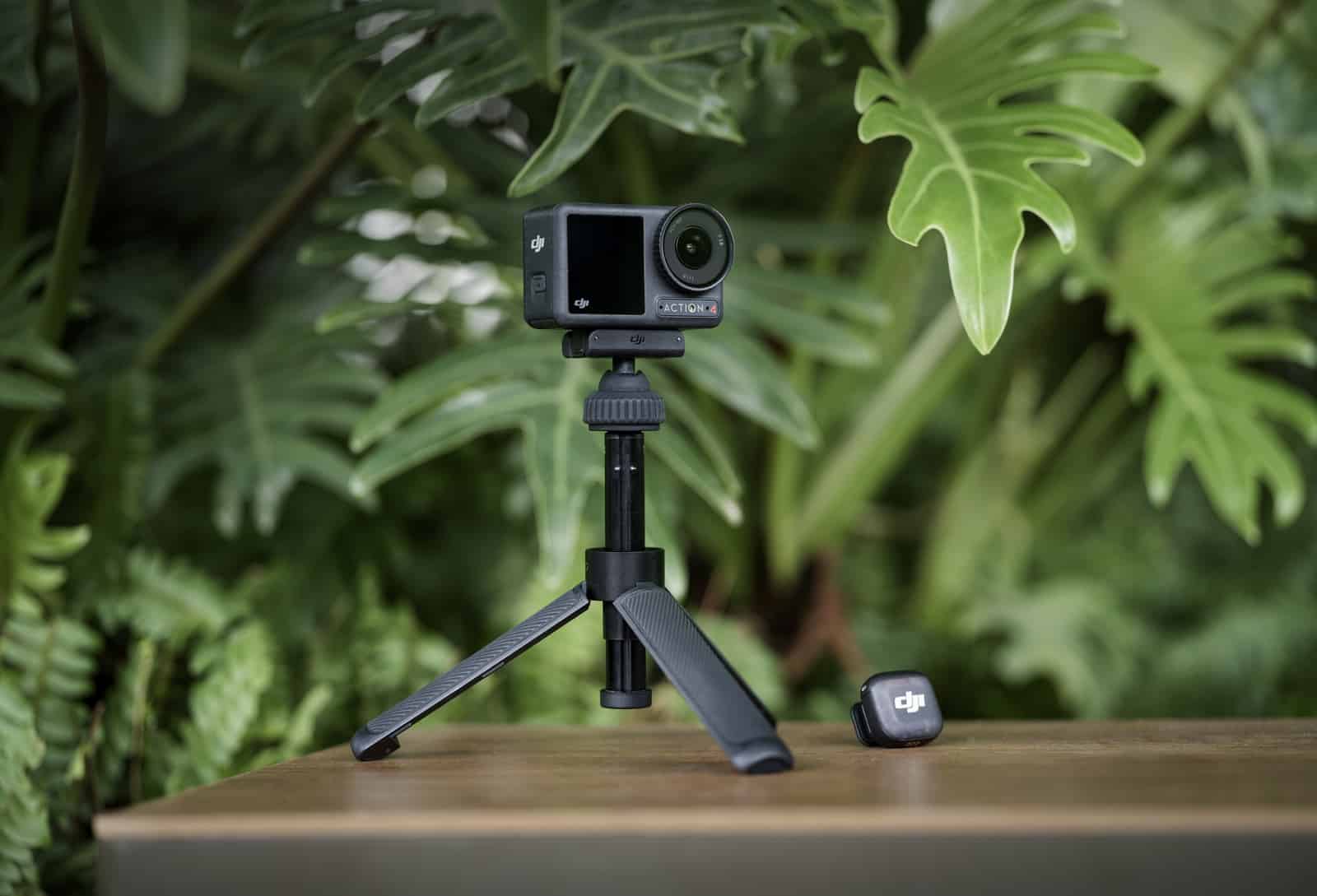 Action camera on a slim mini tripod beside a transmitter on a ledge.
