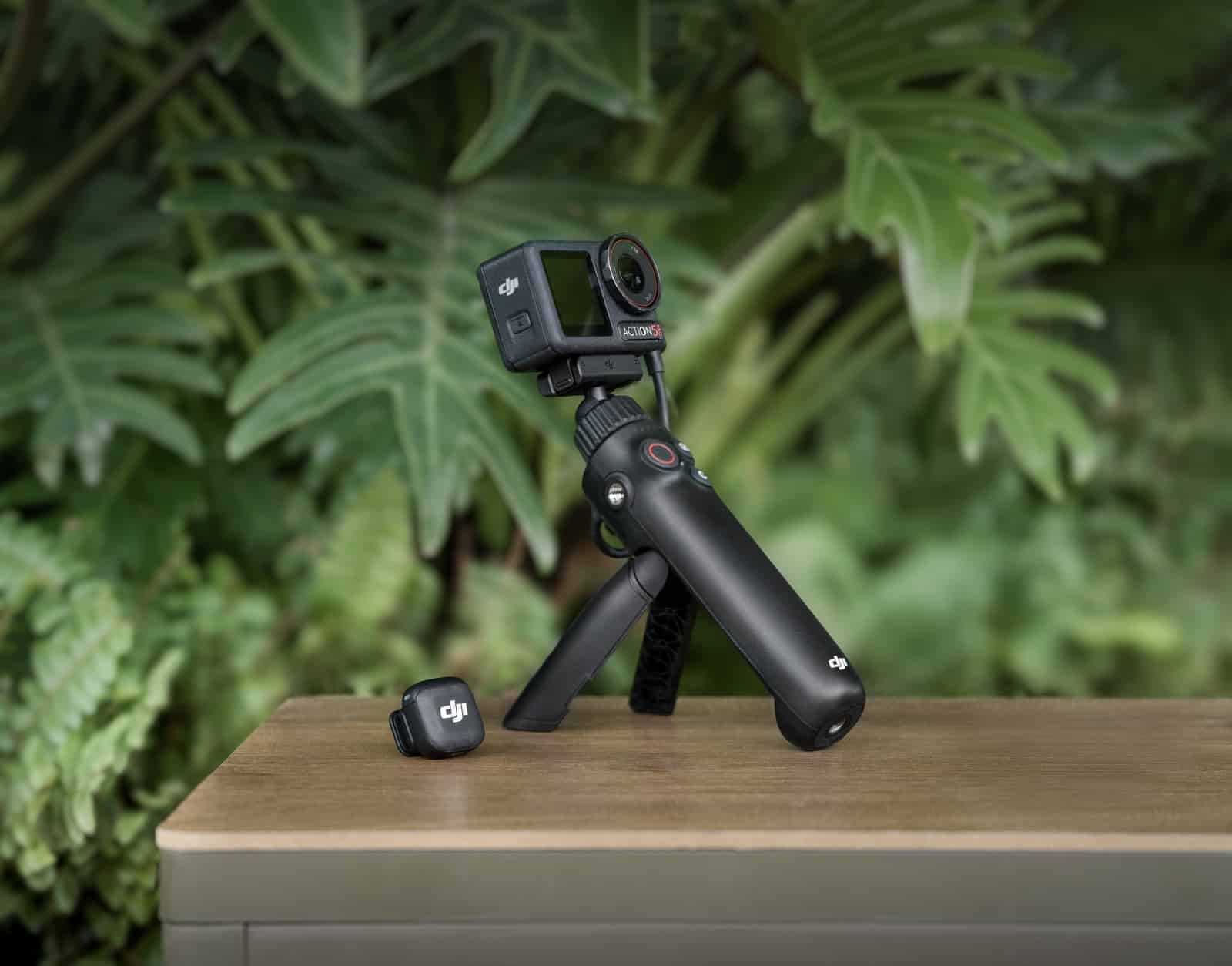 Action camera on a grip tripod with a transmitter standing upright nearby.