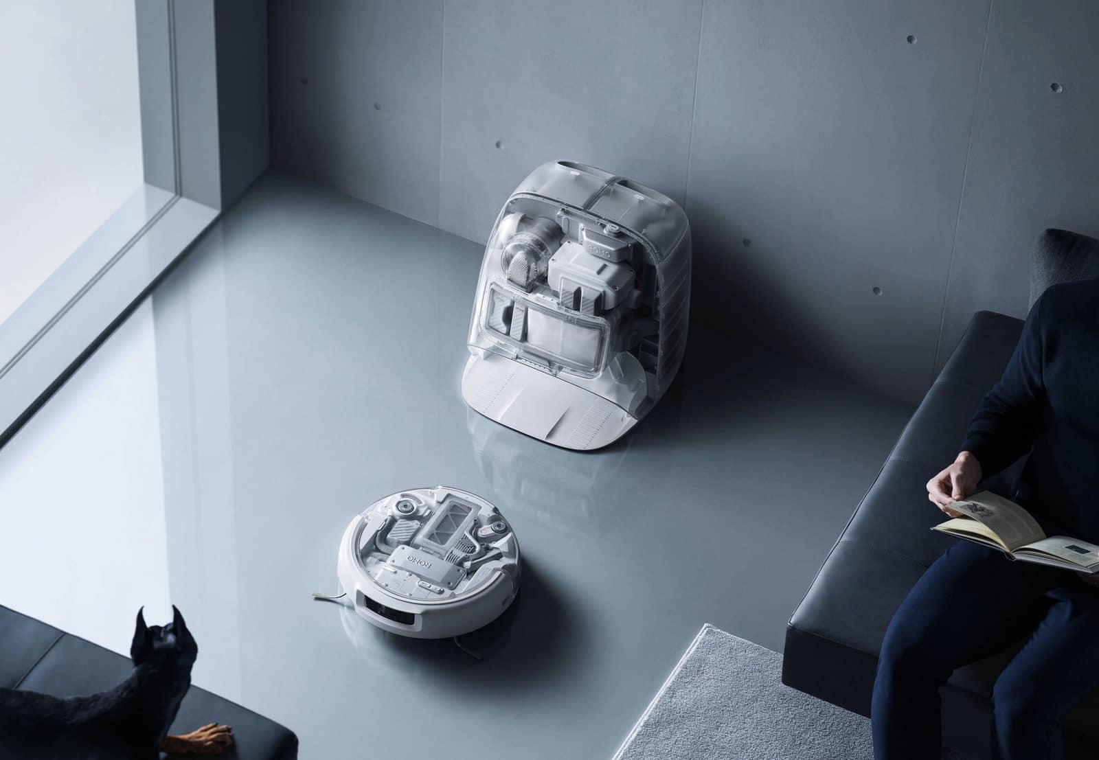 DJI ROMO robot vacuum on a living room floor beneath its wall-mounted docking station.