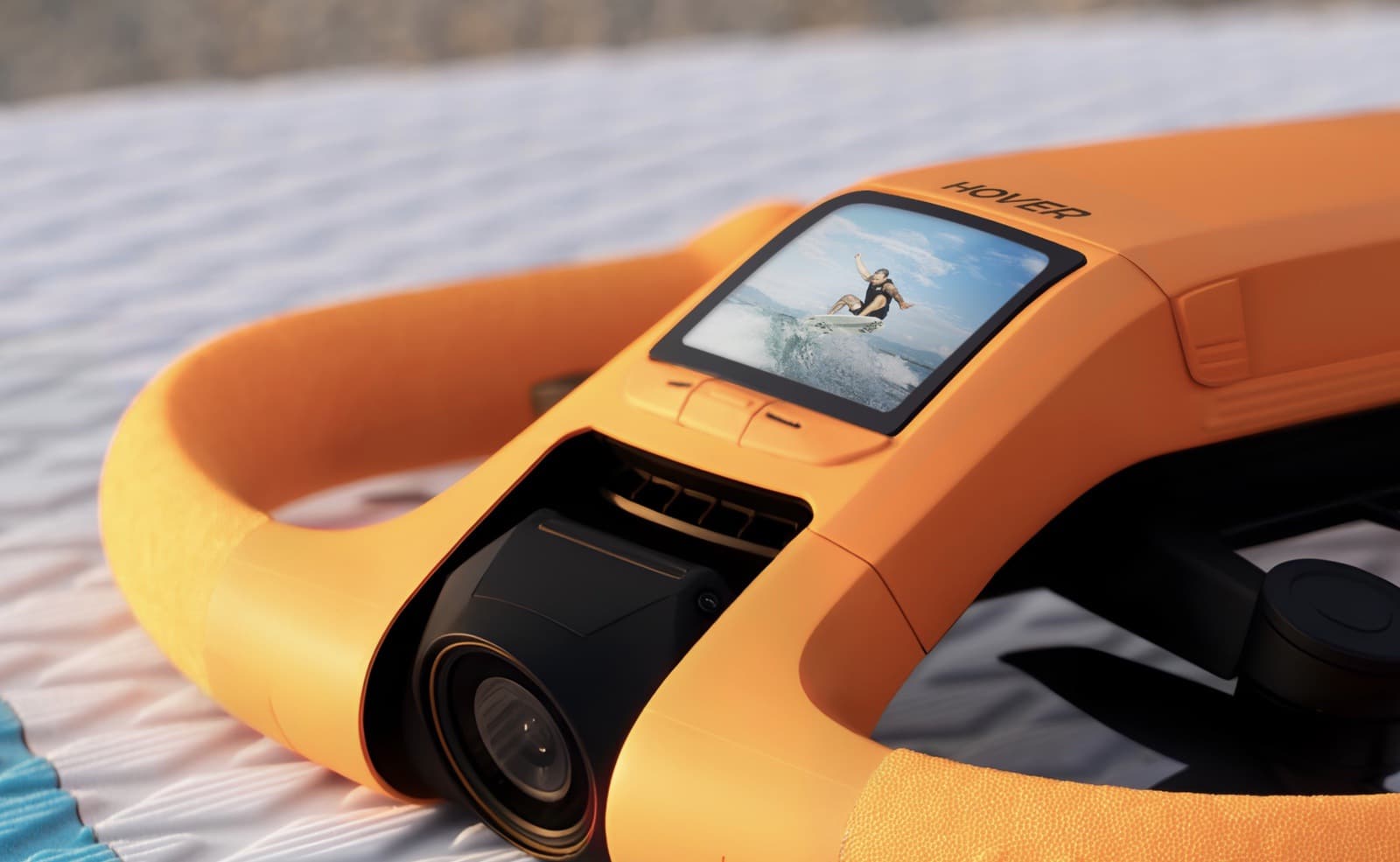 Orange waterproof drone on a white surface with a surfing clip on its display.