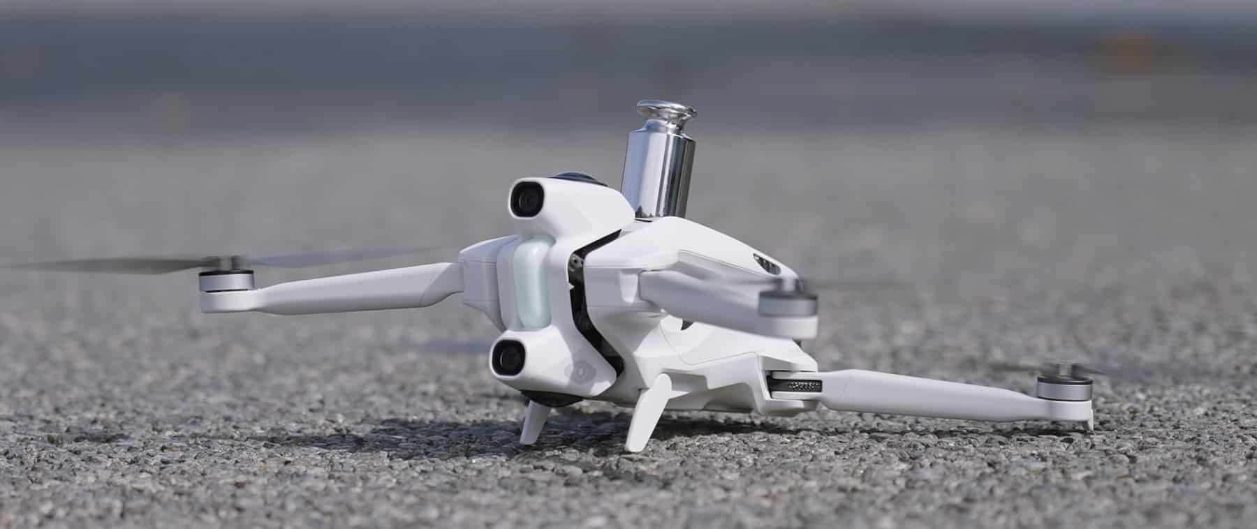 White Antigravity A1 drone resting on gravel with its camera module mounted on top.