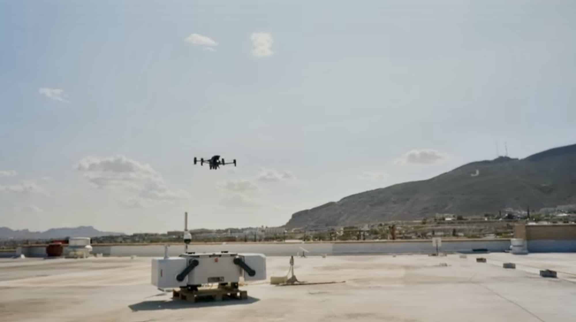 Drone lifting away from a rooftop dock with a desert mountain behind.