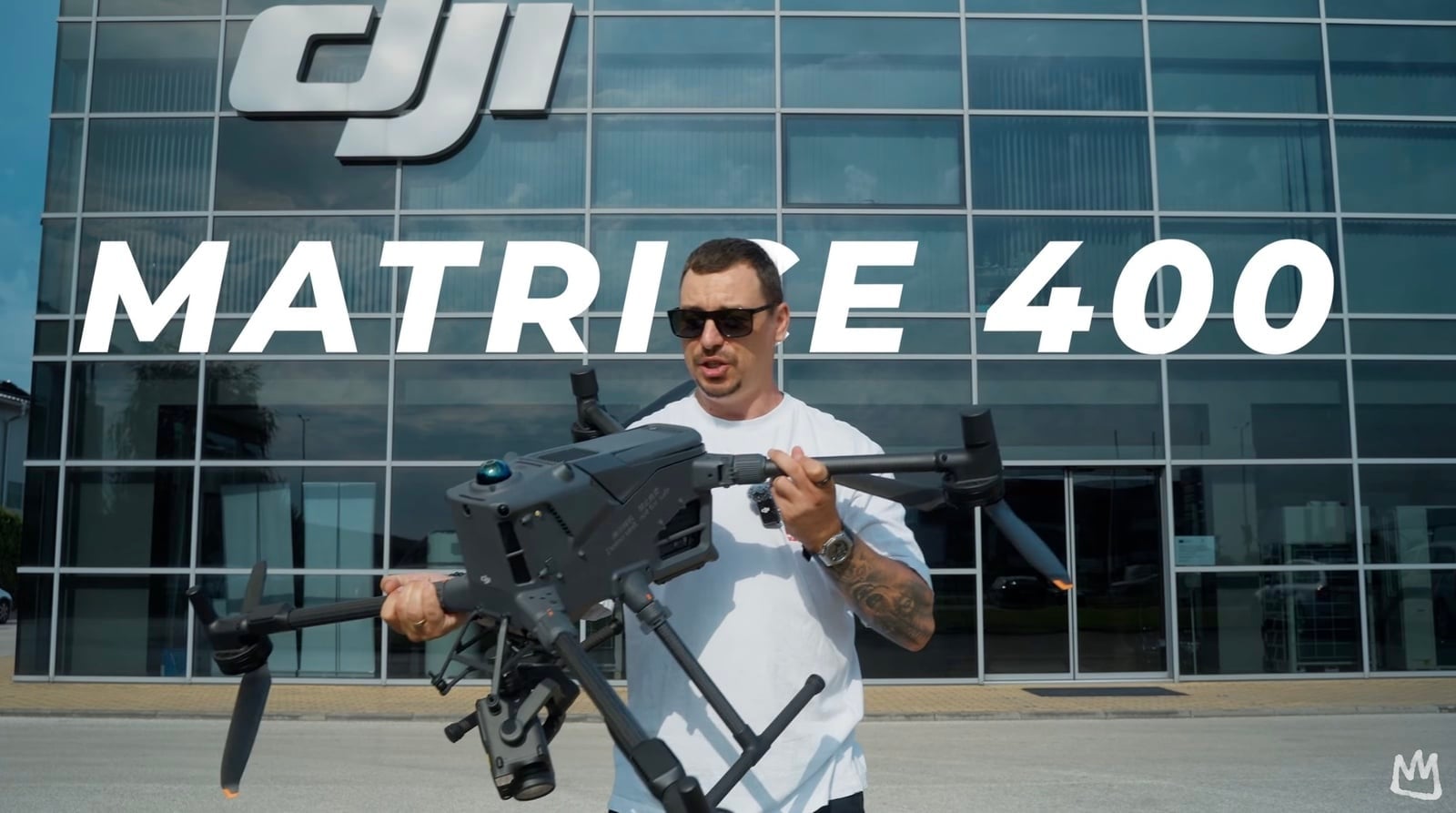 Presenter holds the DJI Matrice 400 outside a DJI office under a title overlay.