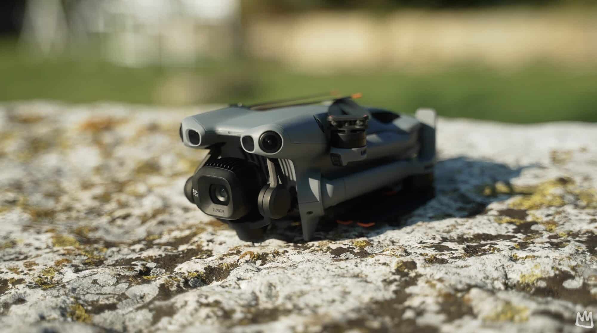 Folded Mini drone resting front-on atop a lichen-covered rock.