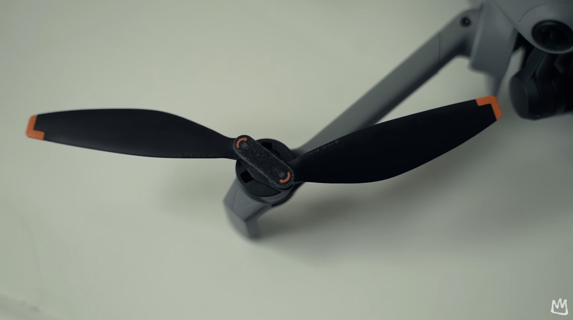 Close-up of a folded DJI Mini 5 Pro arm and its orange-tipped propeller.