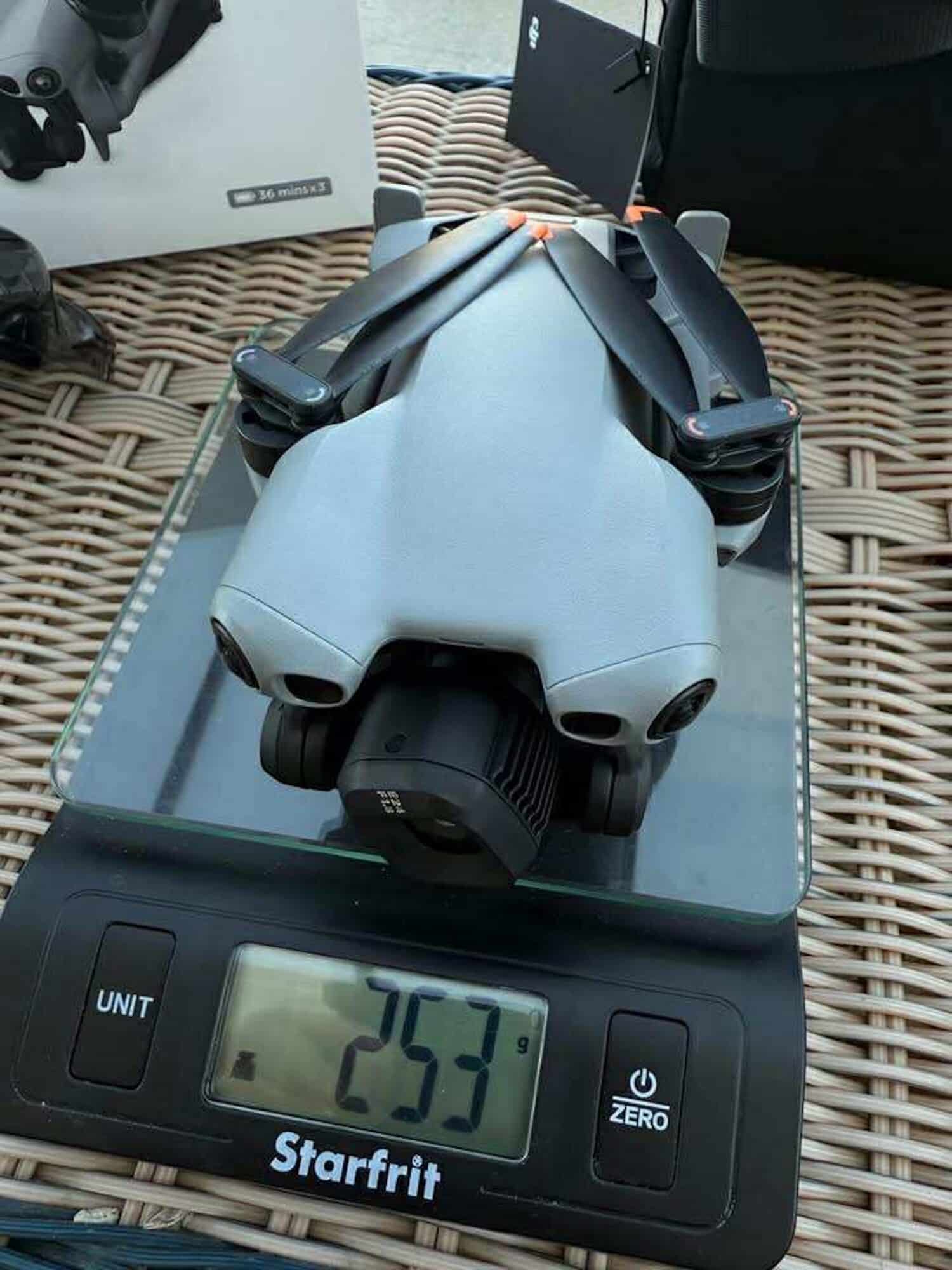 DJI Mini 5 Pro on a kitchen scale reading 253 grams.