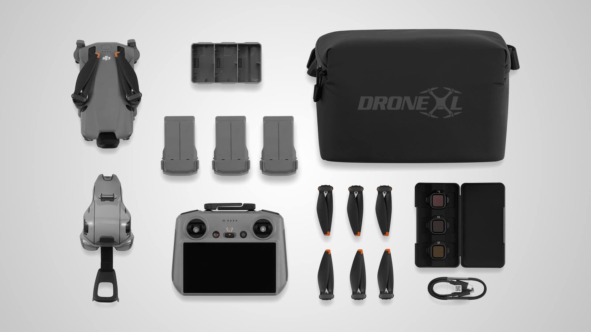 Flat lay of the Fly More Combo with three batteries, controller, spare props and bag.