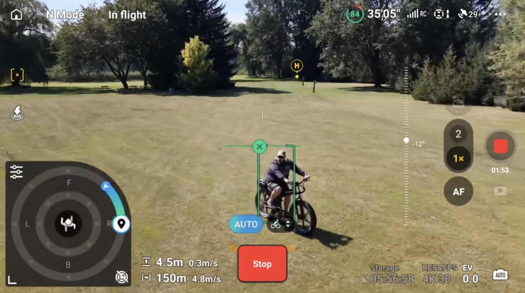 Controller view tracking a cyclist across a grass field inside a green box.