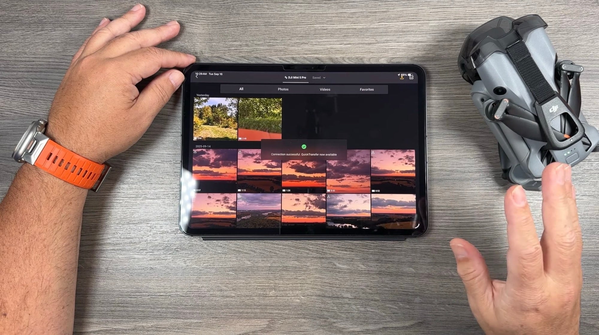 Overhead desk shot of a tablet full of transferred sunset frames beside the folded drone.