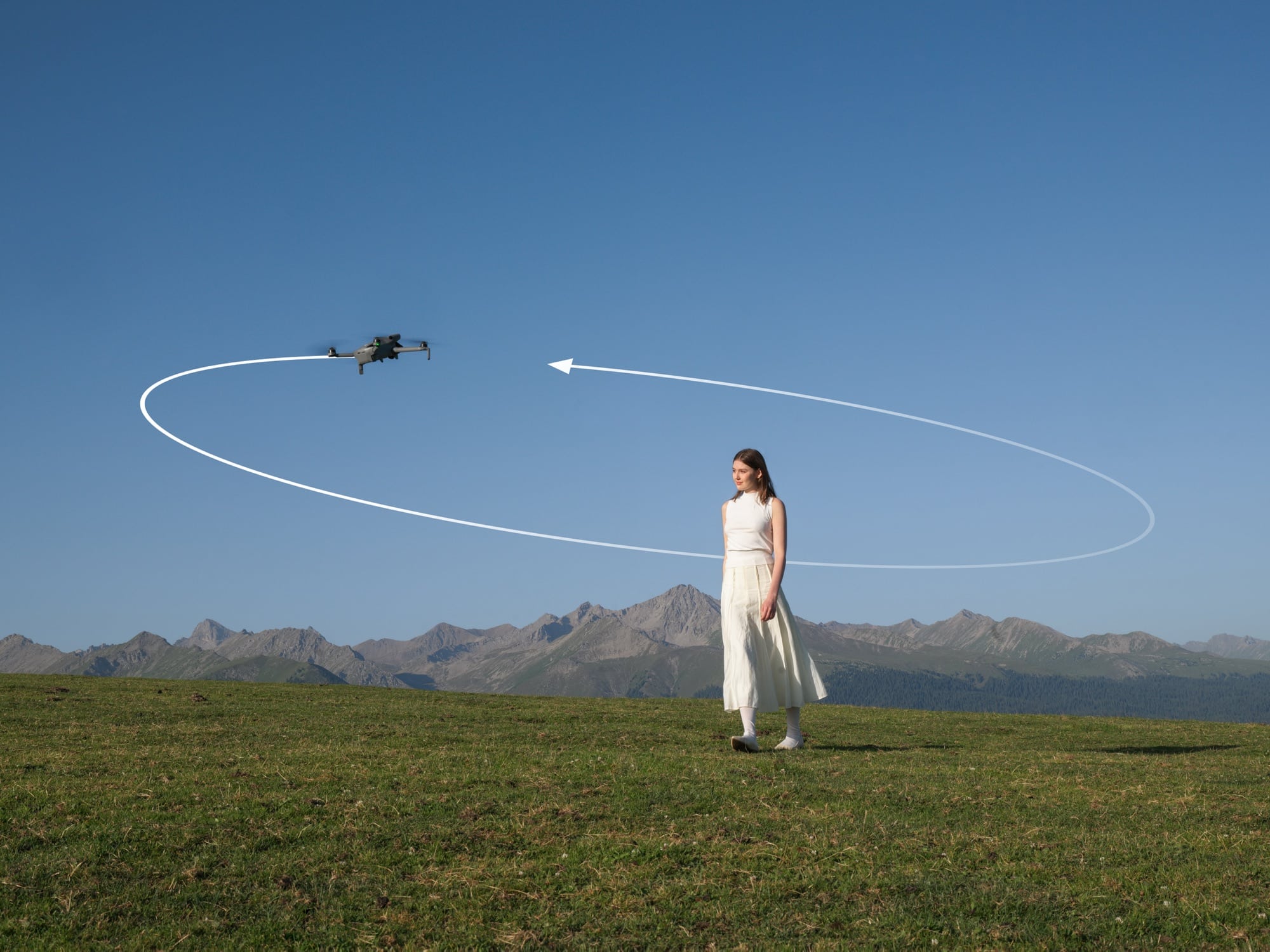 A mini drone traces a circular QuickShot path around a woman in an alpine meadow.