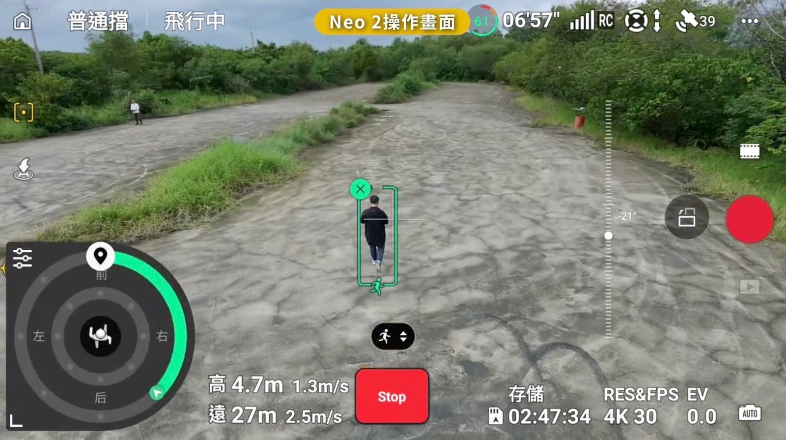 Screenshot of DJI Fly tracking a walker on a stony riverbed path.