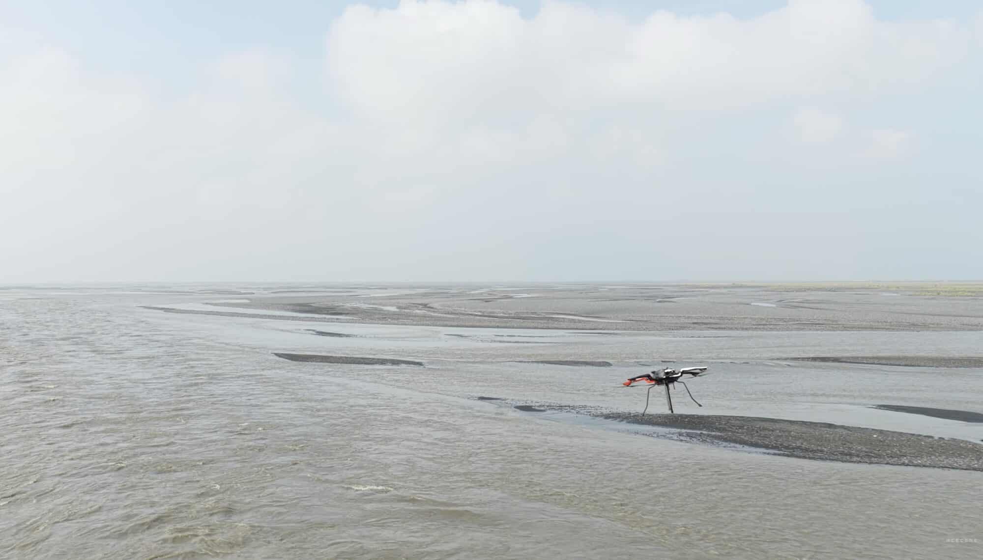 Acecore Noa hexacopter flying low over a wide flat expanse of shallow water.