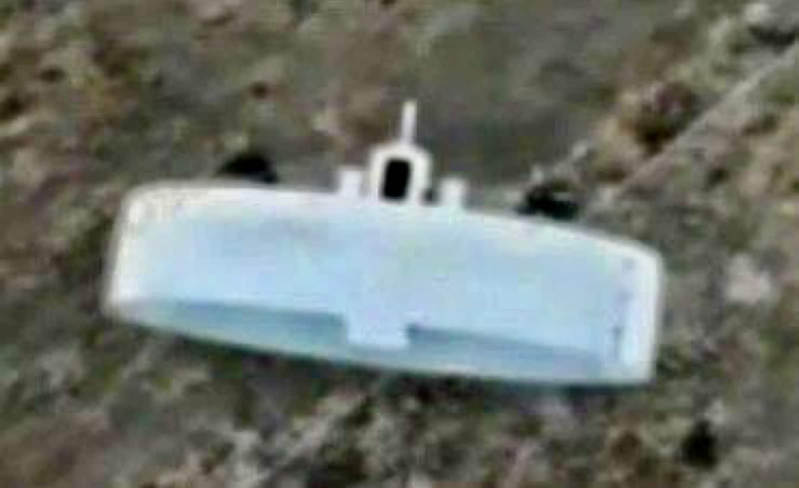 Blurred frame of a Russian ring-wing drone flying above scrubland.