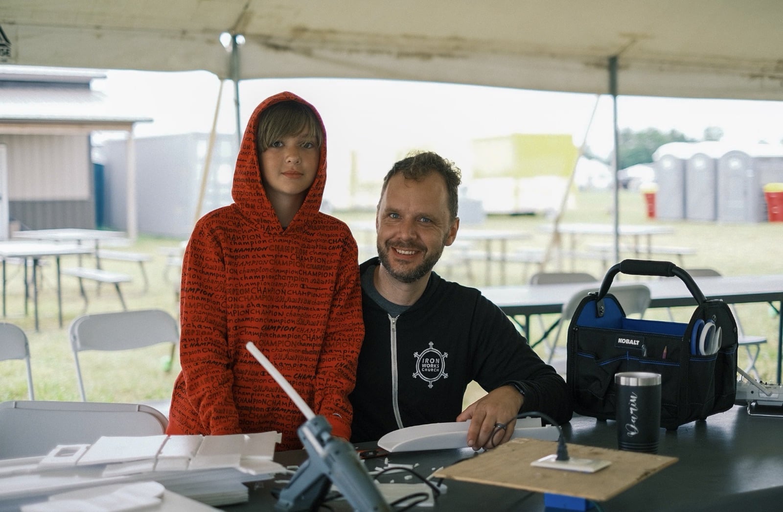 An attendee holding up a homebuilt model for the camera at Flite Fest 2023.