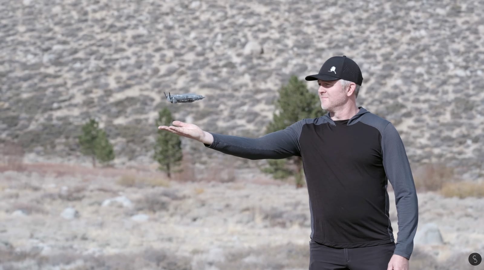 The DJI Neo 2 in hand, showing its front display, lidar sensor and mode buttons.