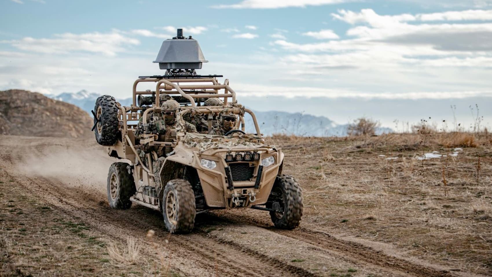 Counter-drone sensor unit mounted on a tan military buggy racing across desert.