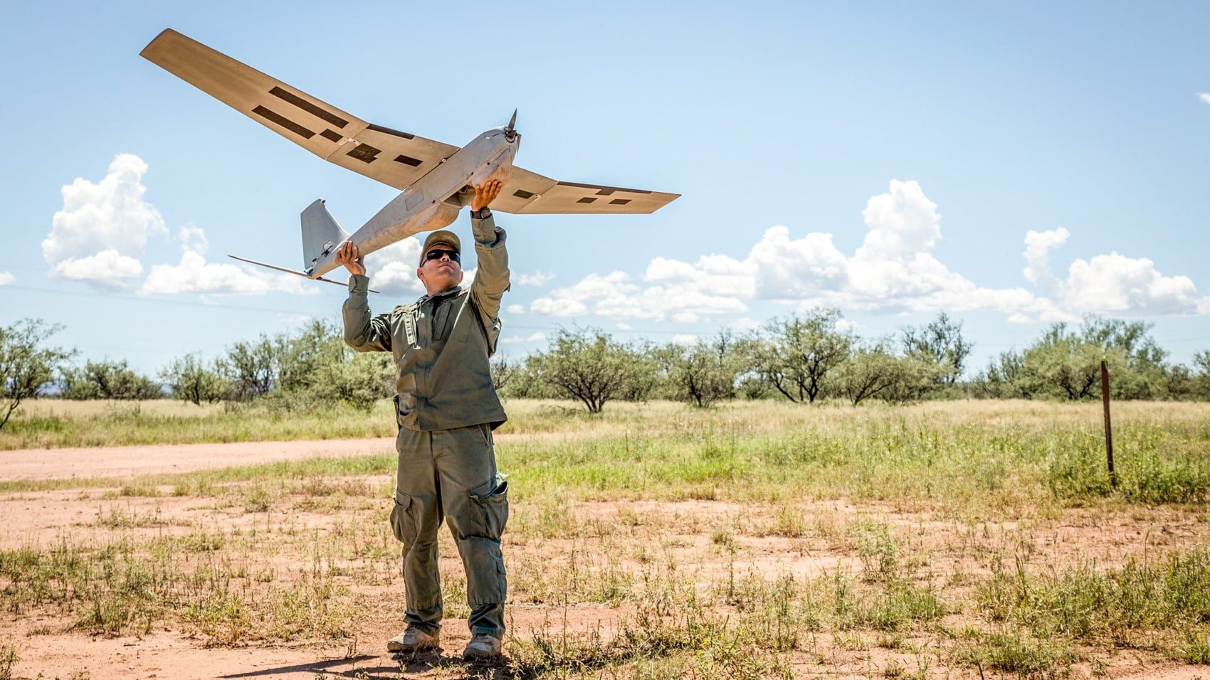 A Border Patrol agent prepares to hand-launch a fixed-wing surveillance drone.