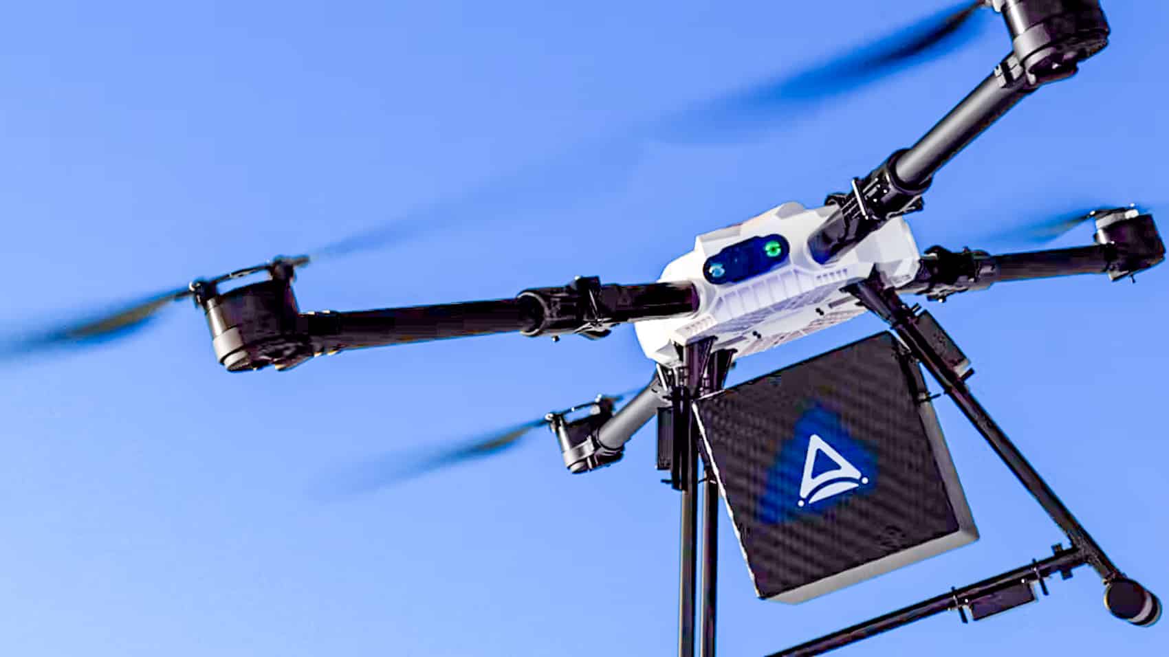 An Amber Wings heavy-lift multirotor flying with a slung cargo load.