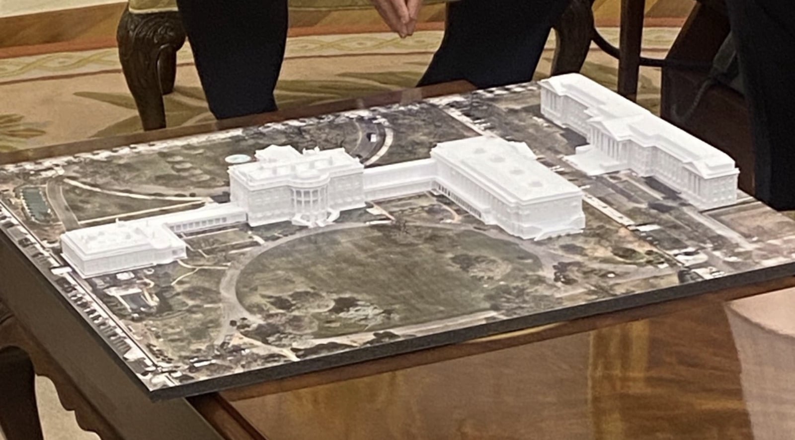 Architectural scale model of the White House and its proposed ballroom on a table.