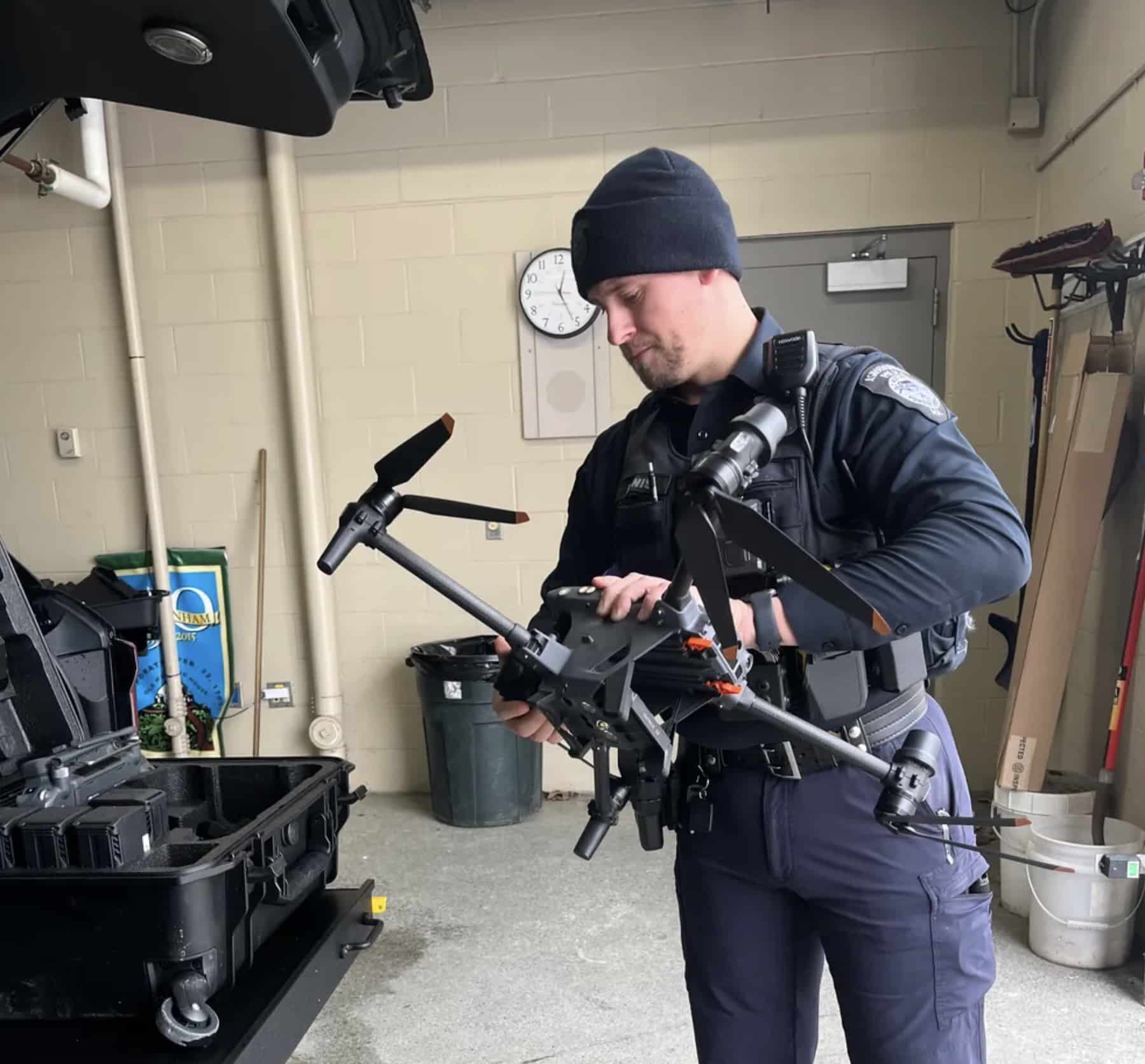Ashburnham police officer preparing a folded quadcopter beside its transport case.
